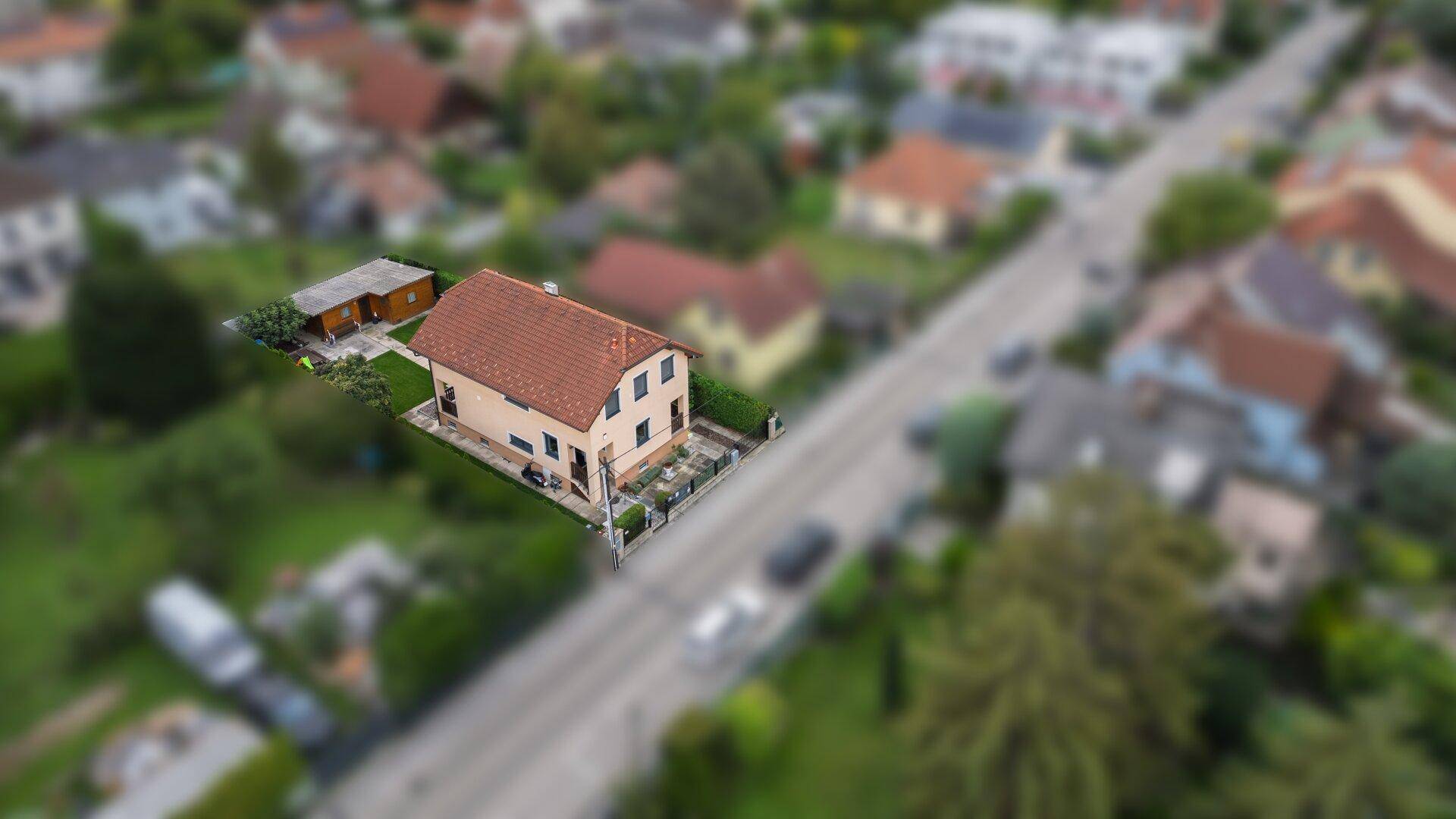 Weitläufige Luftaufnahme des Grundstücks mit Haus, Garten und der umgebenden Bebauung.