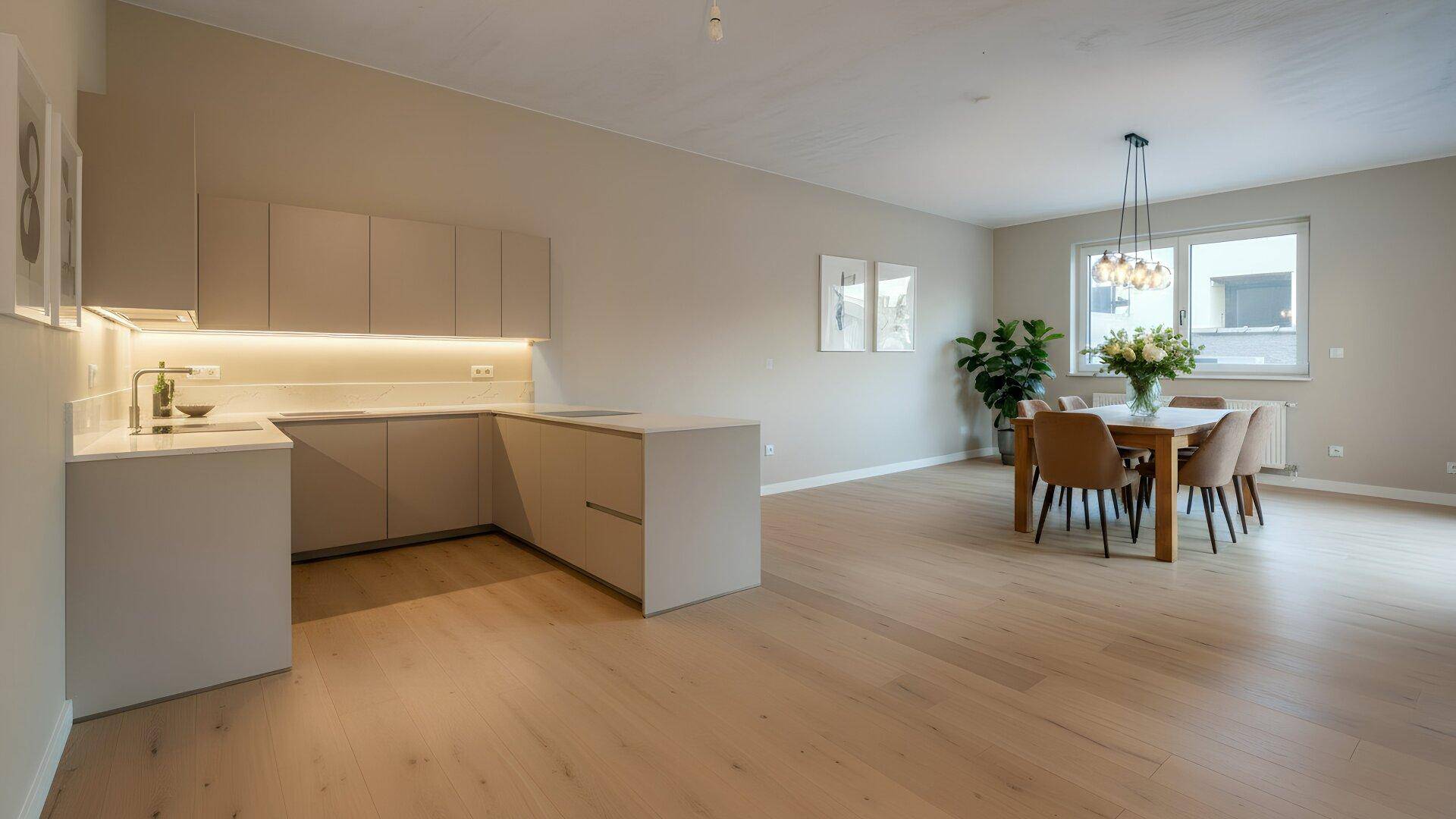 Offener Wohn-Essbereich mit moderner Einbauküche, Holzboden und Esstisch.