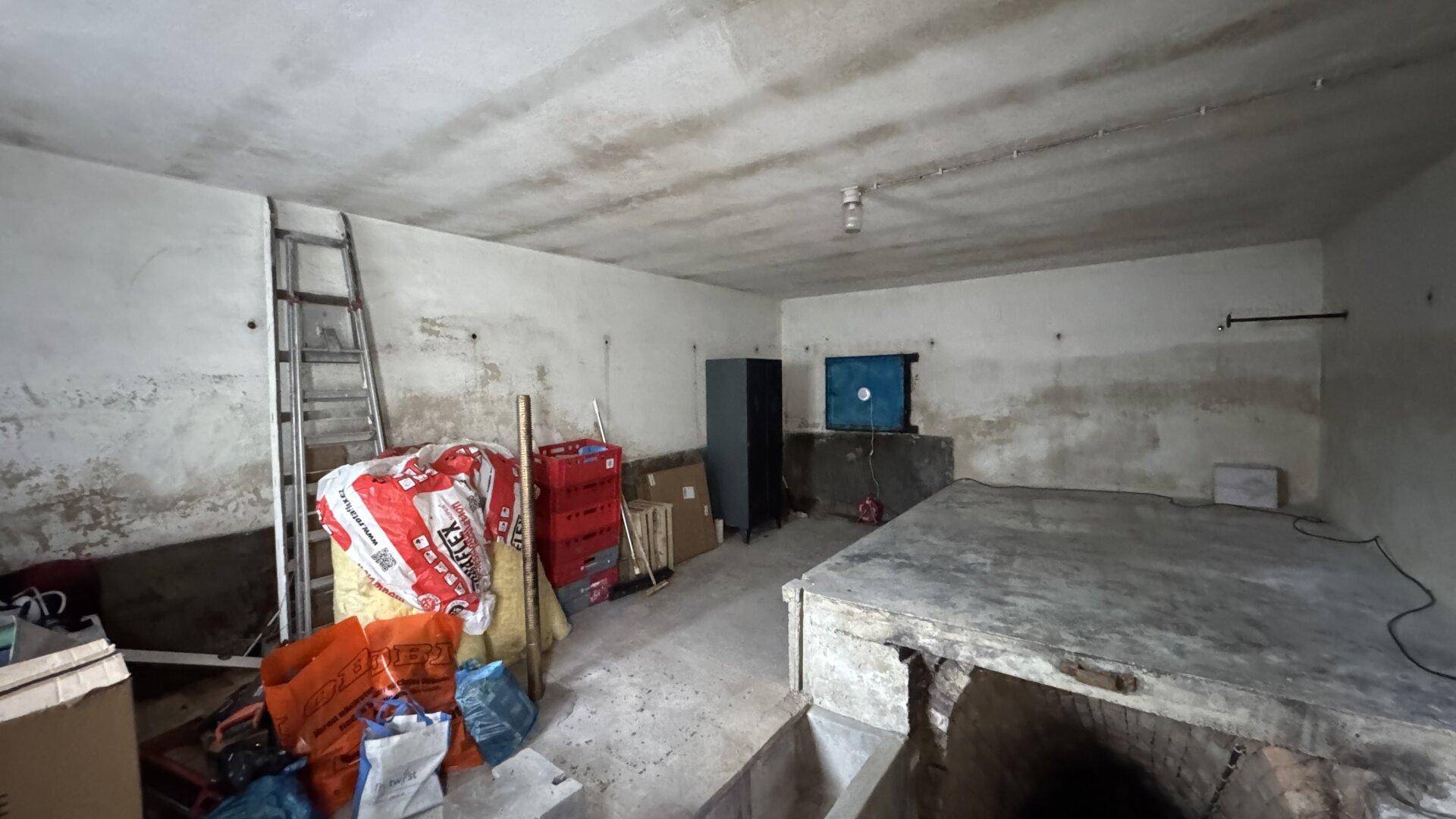 Unfertiger Kellerraum mit Betonboden und Lagerflächen, bereit für Renovierung.