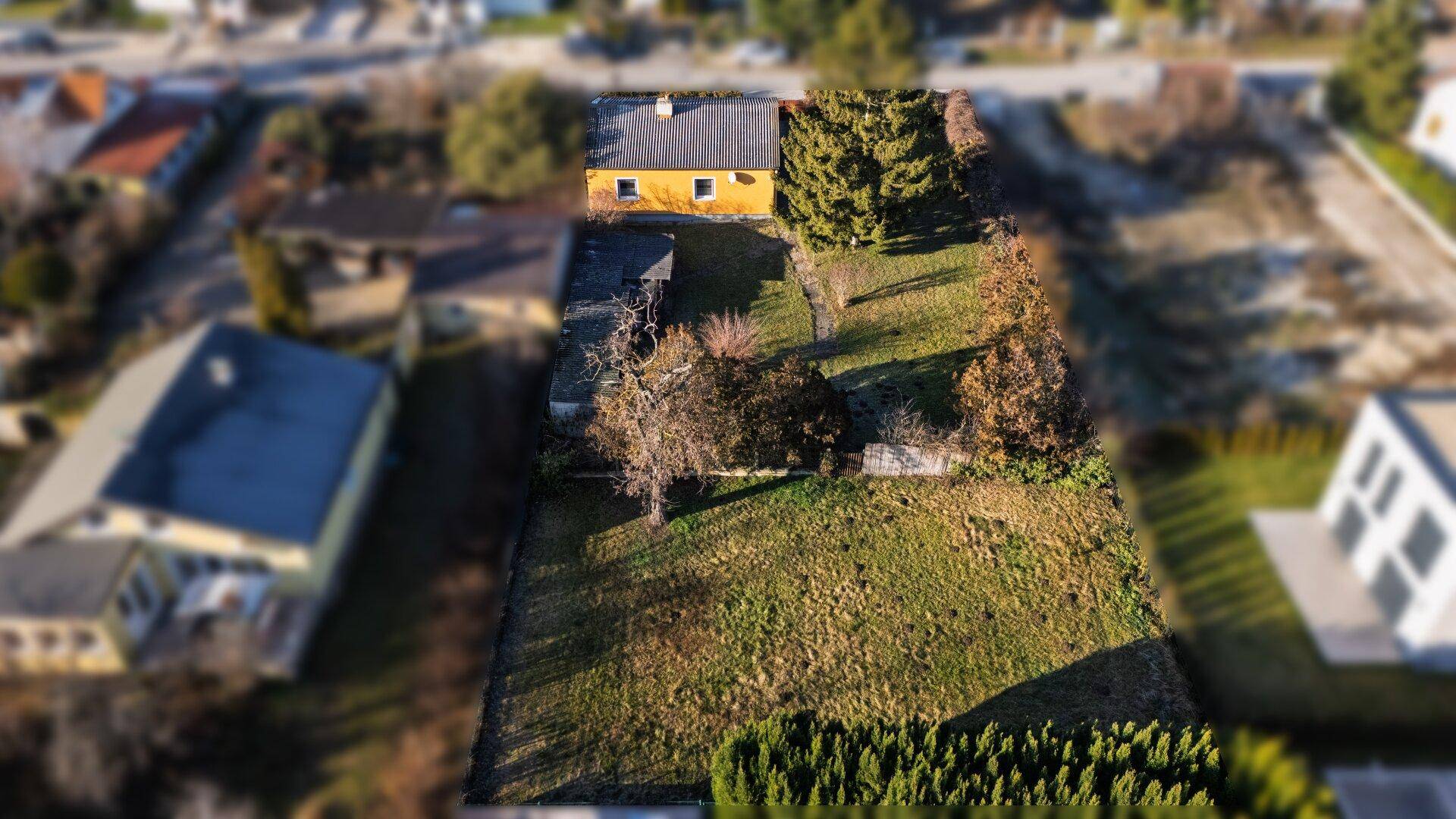 Luftaufnahme des Grundstücks mit dem Haus und der langgestreckten Gartenfläche.