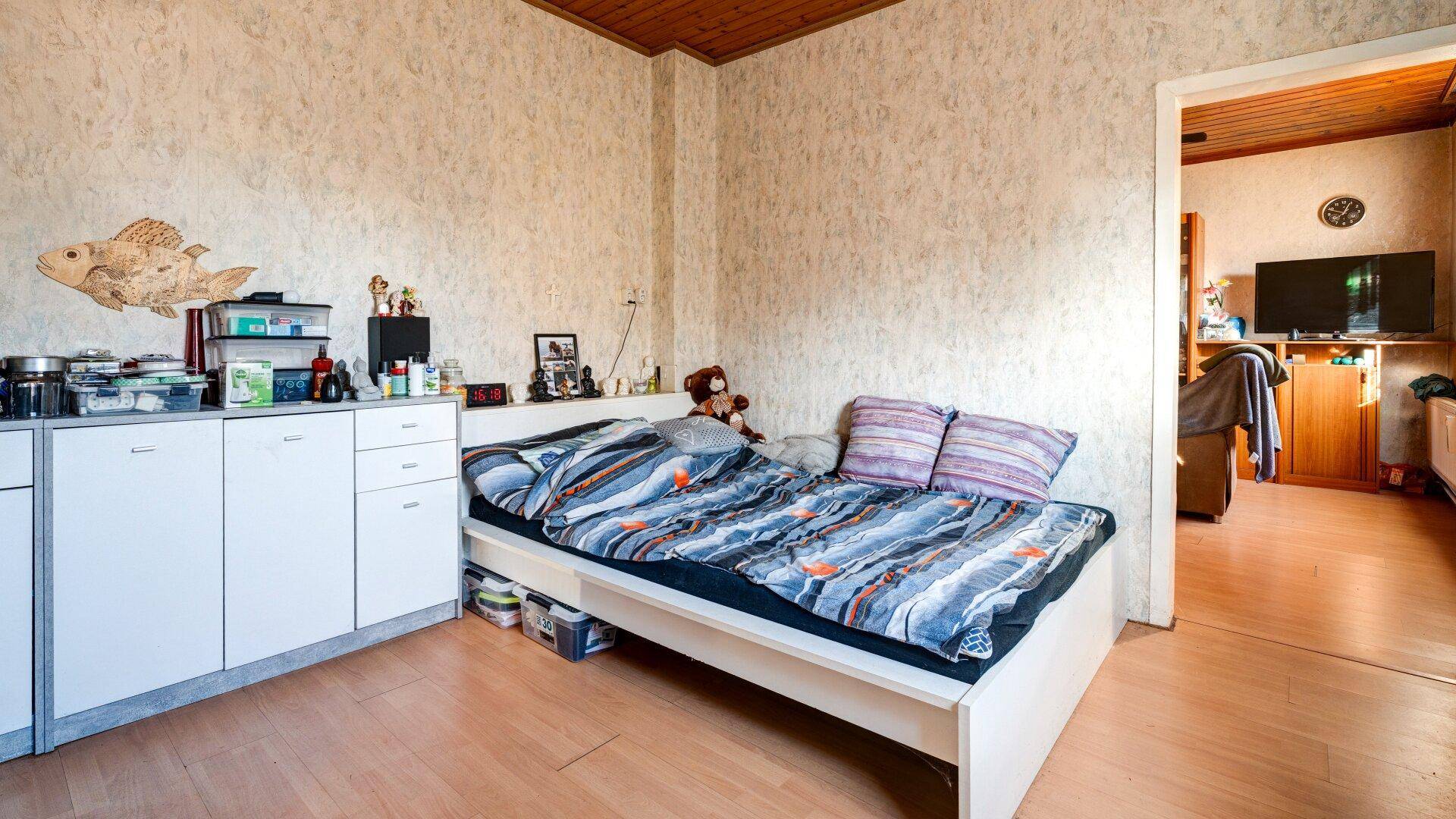 Schlafzimmer mit einem Schrank und einem Einzelbett, das den Raum funktional gestaltet.