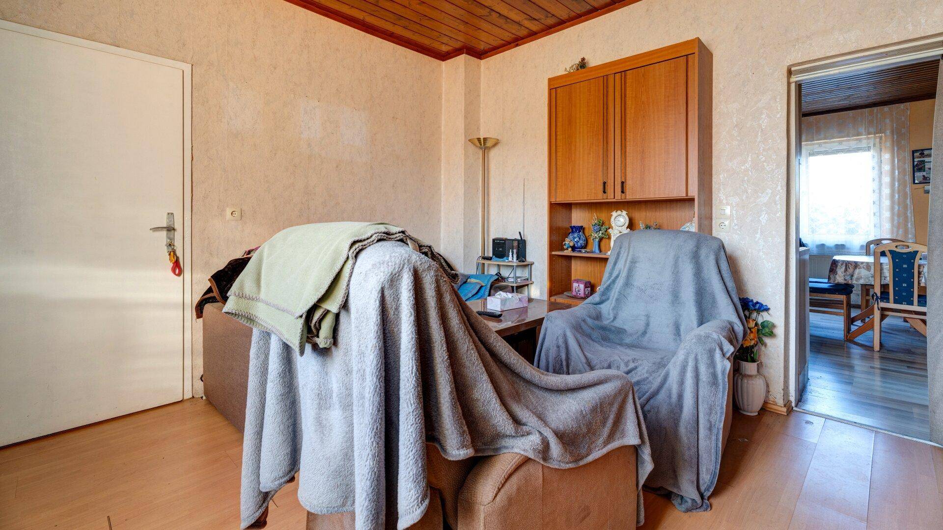 Wohnzimmer mit einem Schrank und bequemen Sesseln, die zum Entspannen einladen.