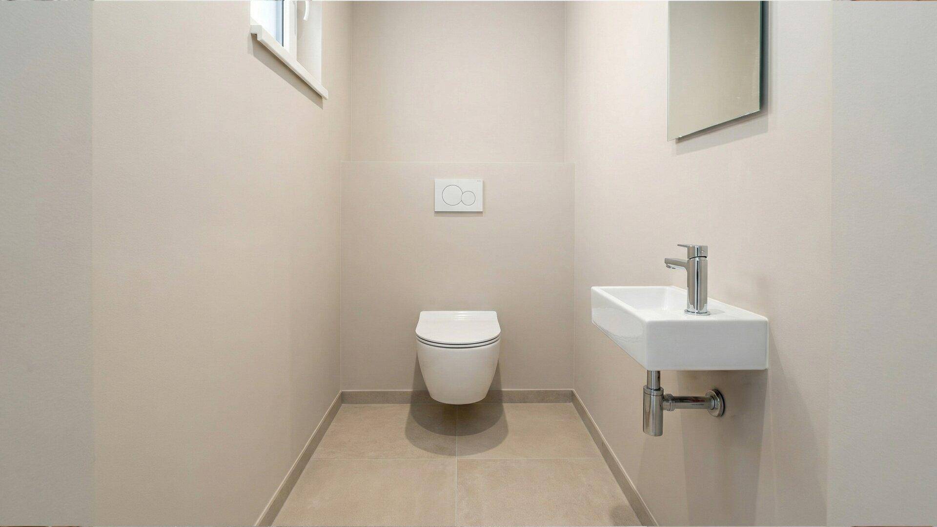 Modernes Gäste-WC mit wandhängendem WC, kleinem Waschbecken und Fliesenboden.