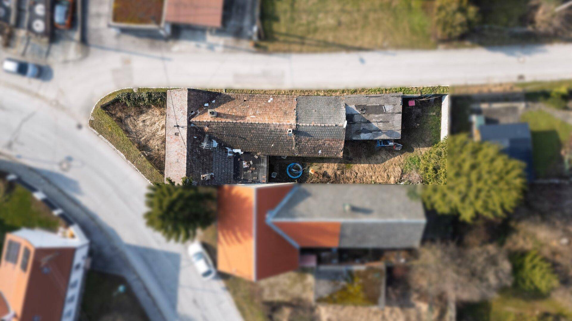 Draufsicht auf das Grundstück mit dem Haus und den angrenzenden Gebäuden.