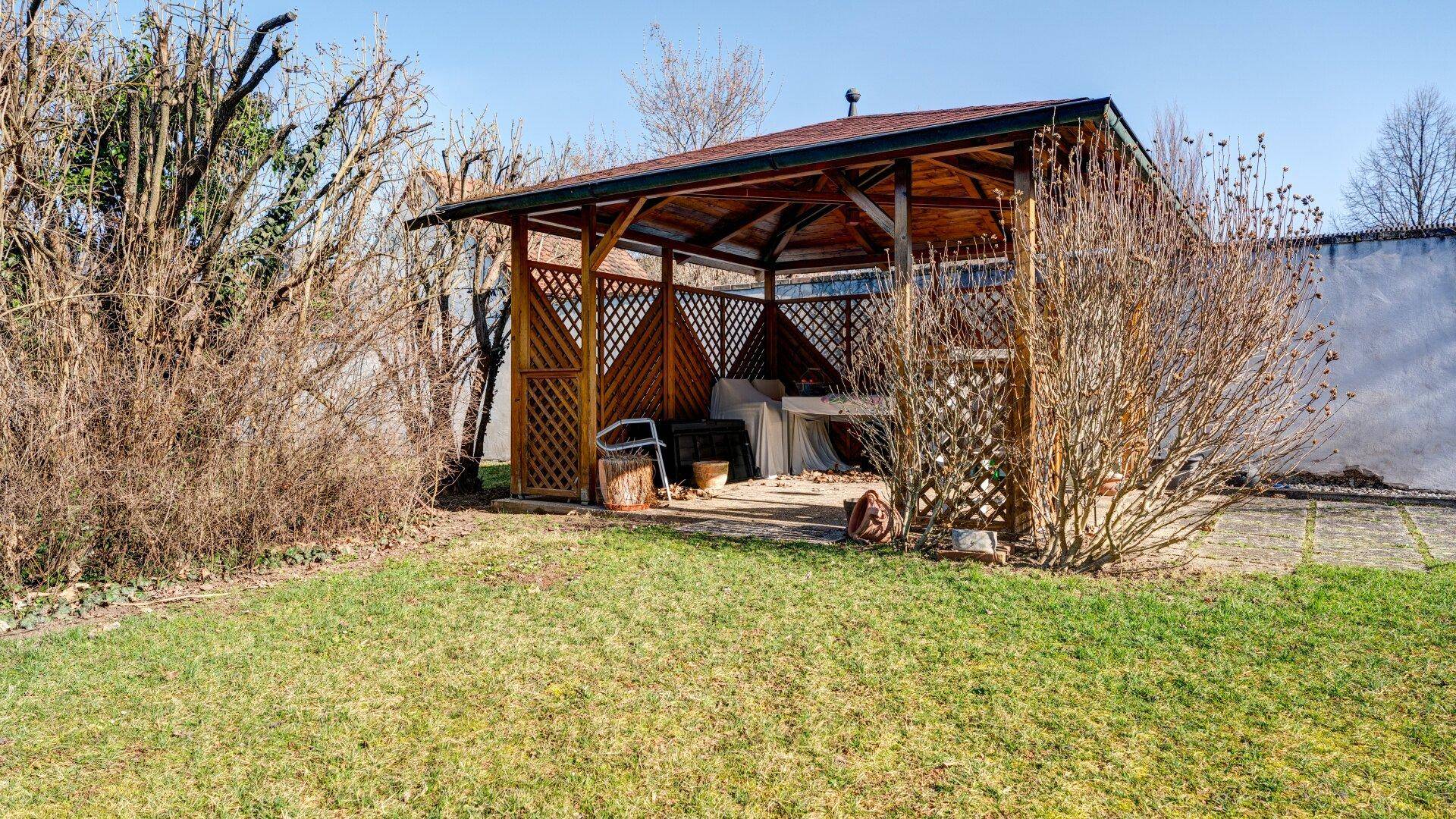 Gartenbereich mit Holzpavillon und Rasenfläche, ideal für entspannte Stunden im Freien.