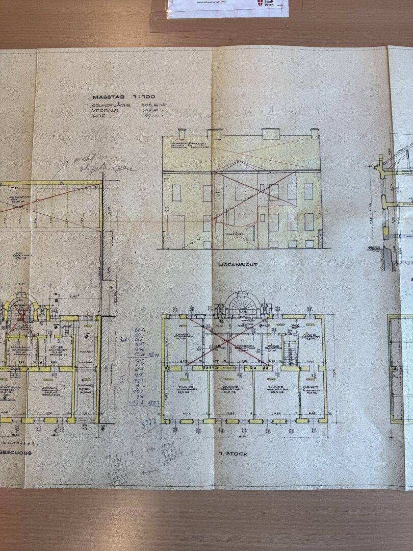 Detaillierte Baupläne des Gebäudes mit Grundrissen der Stockwerke und Hofansicht, handgezeichnete Details.