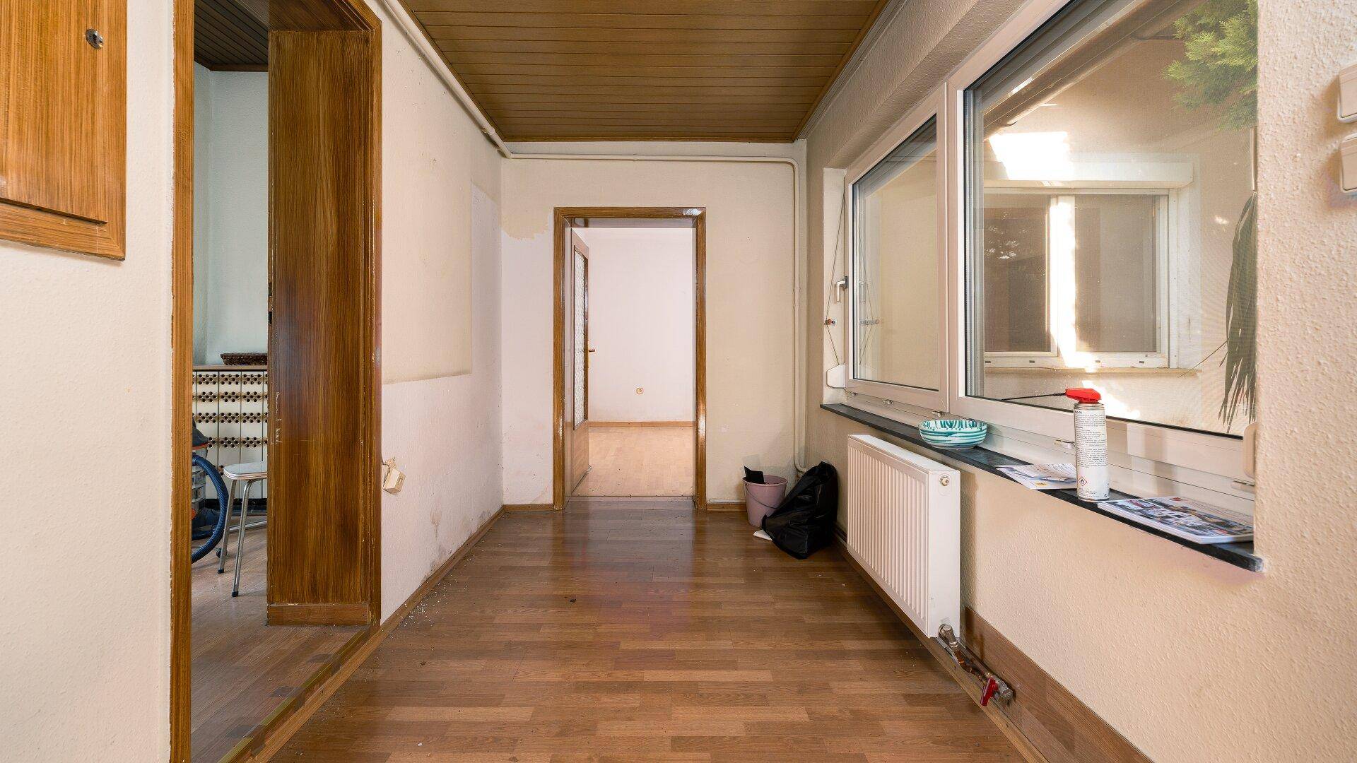 Heller Flur mit Holzdecke und Parkettboden, der zu weiteren Räumen im Haus führt.