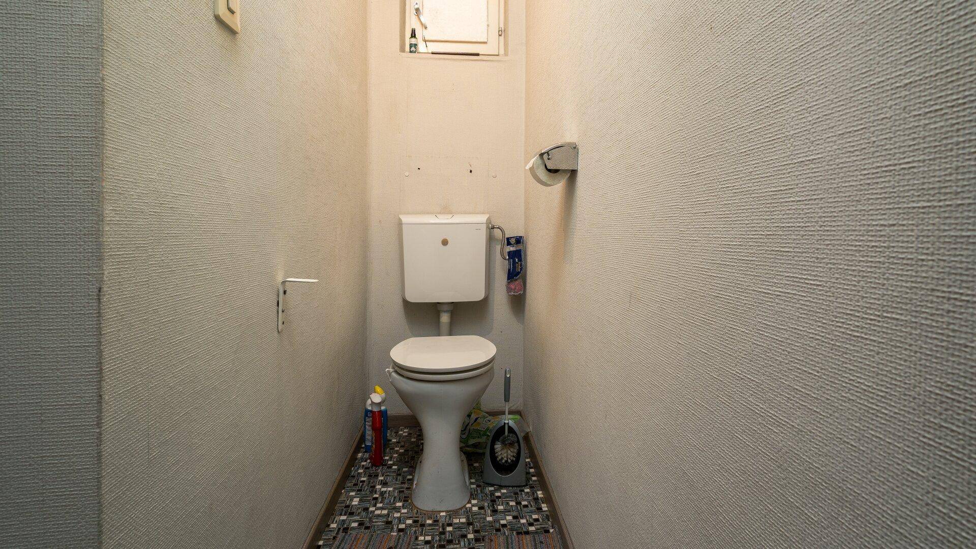 Kleines Gäste-WC mit Steh-WC und gemustertem Fliesenboden in schlichtem Design.