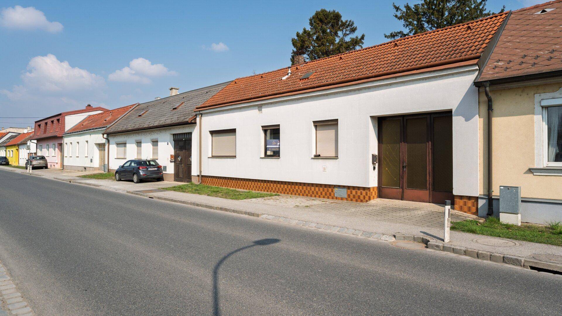 Blick auf die Straße mit dem Haus und weiteren Wohnhäusern in der Umgebung.