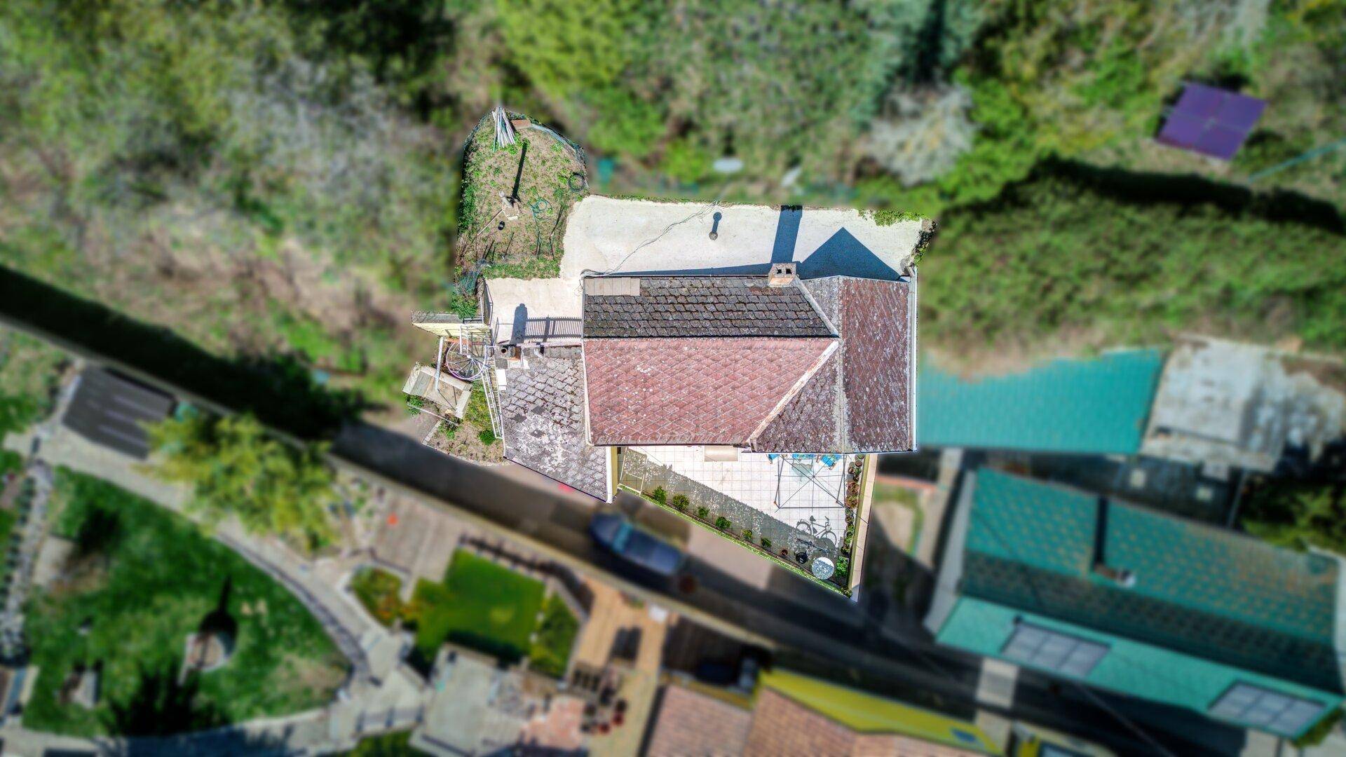 Luftaufnahme des Hauses mit Satteldach und umliegender grüner Landschaft.