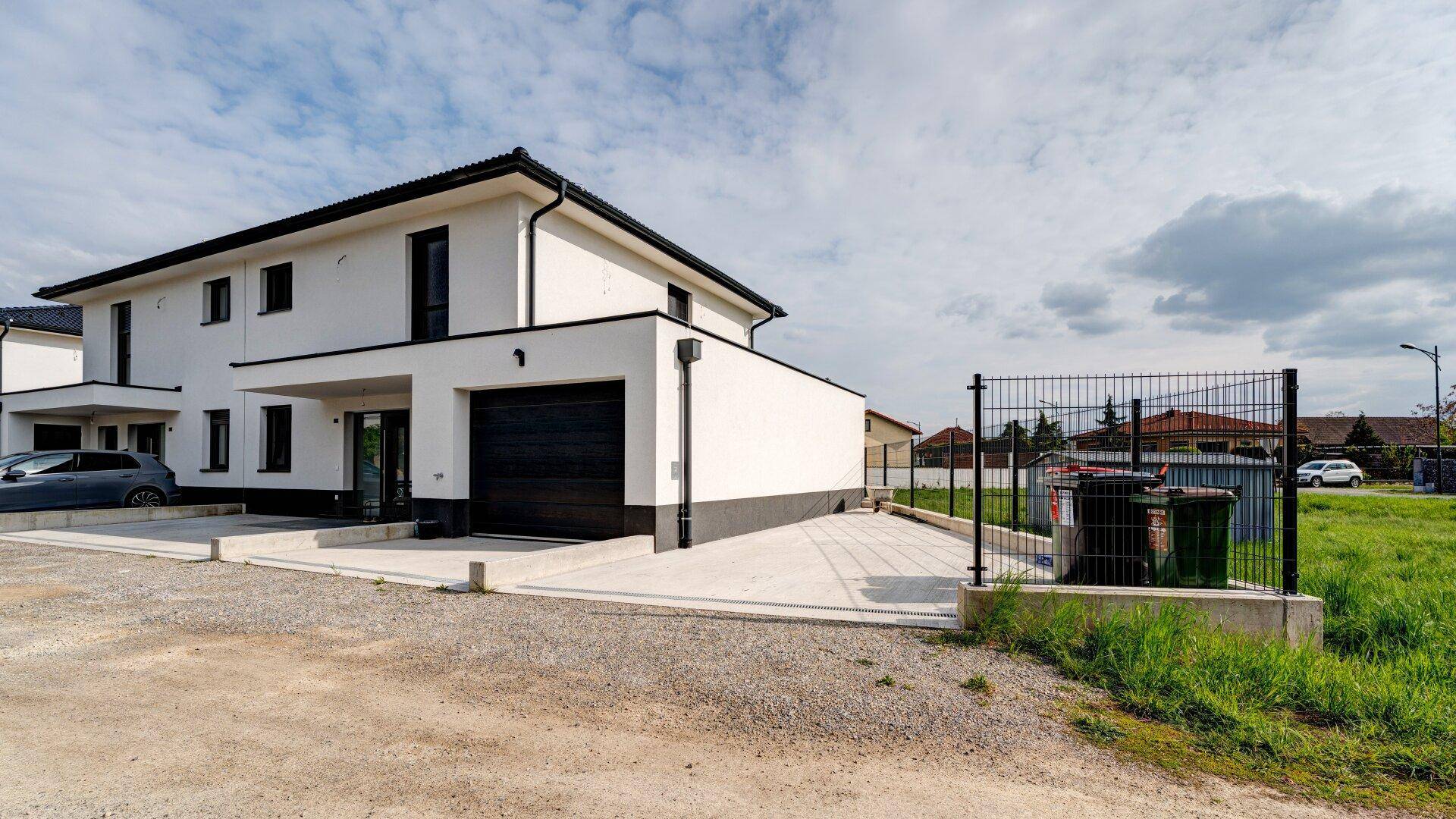 Ansicht der modernen Doppelhaushälfte mit Garage und Zufahrt.