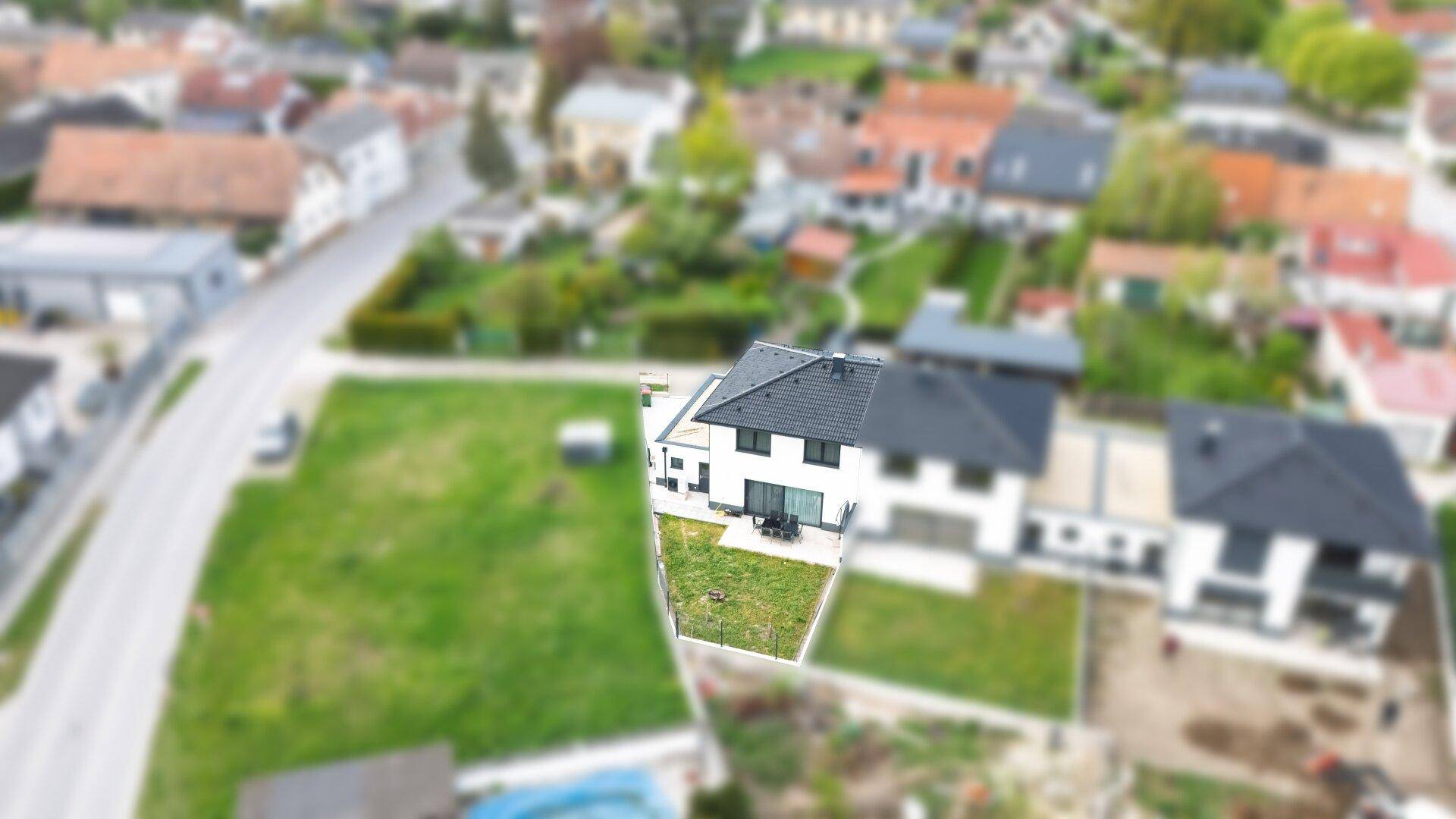 Vogelperspektive des Hauses mit Garten und der umliegenden Wohnsiedlung.