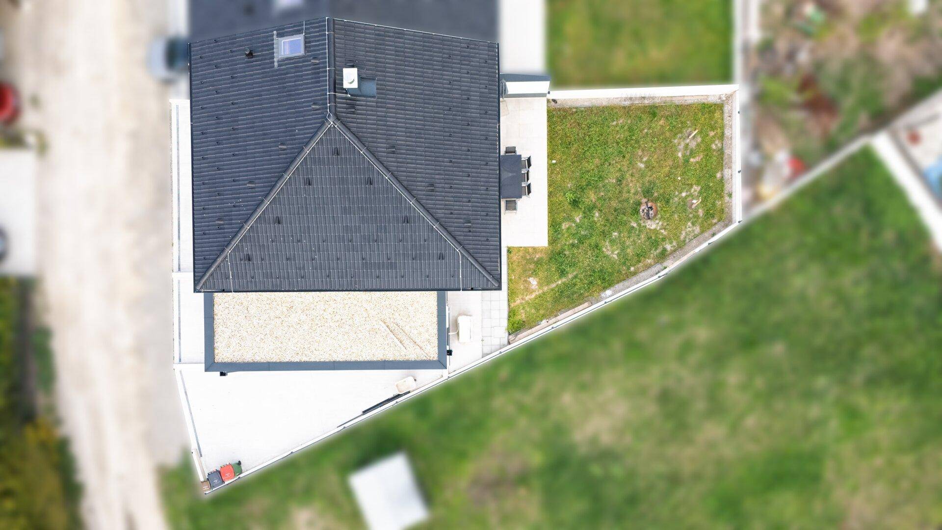 Luftaufnahme des Hauses mit Satteldach, Garten und angrenzenden Grundstücken.