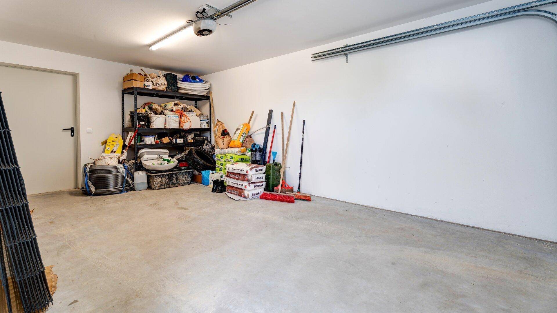 Geräumige Garage mit Betonboden und Stauraum.