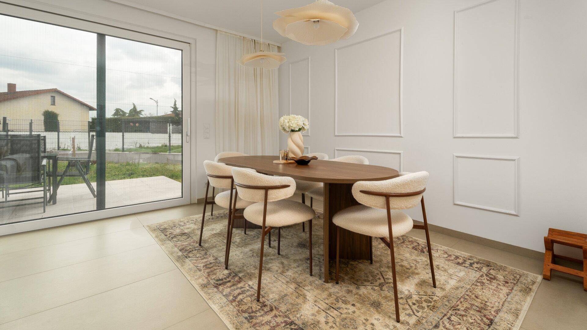 Eleganter Essbereich mit Holztisch, bequemen Stühlen und Zugang zur Terrasse.