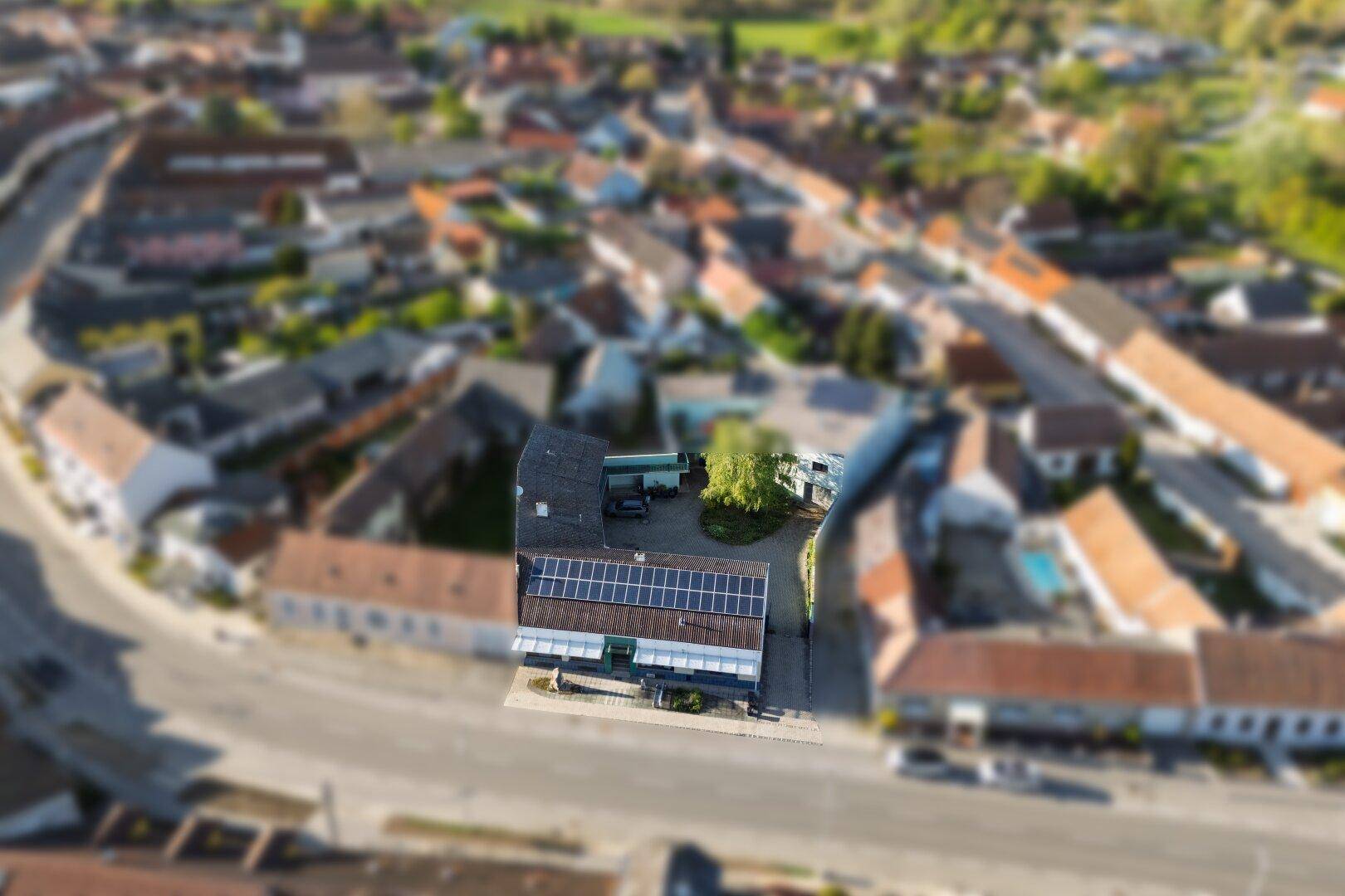 Panoramische Luftaufnahme des Anwesens mit Solaranlage und Blick auf die umliegende Siedlung.