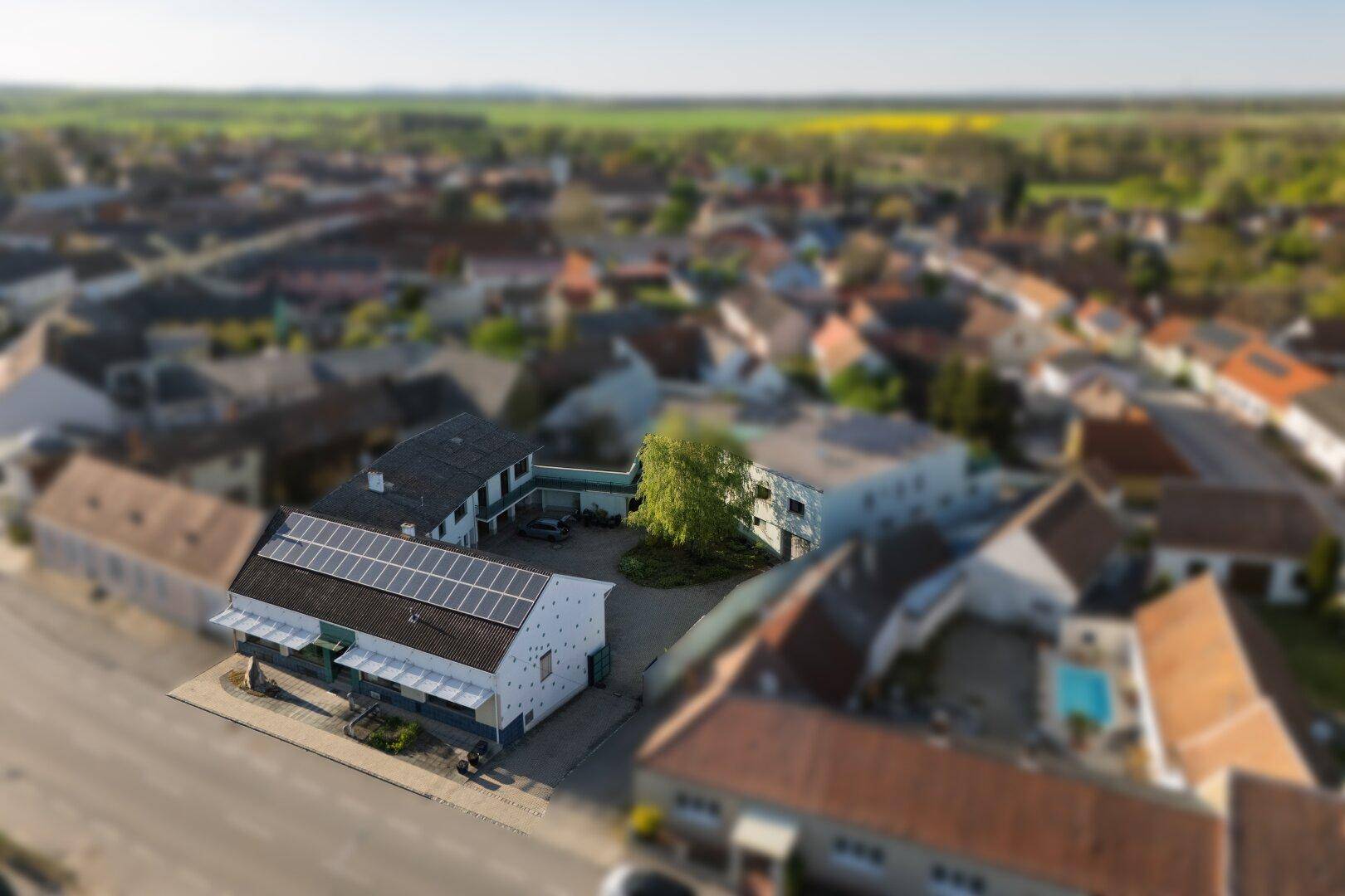 Übersichtliche Luftaufnahme des Anwesens mit Solaranlage und der angrenzenden Bebauung.