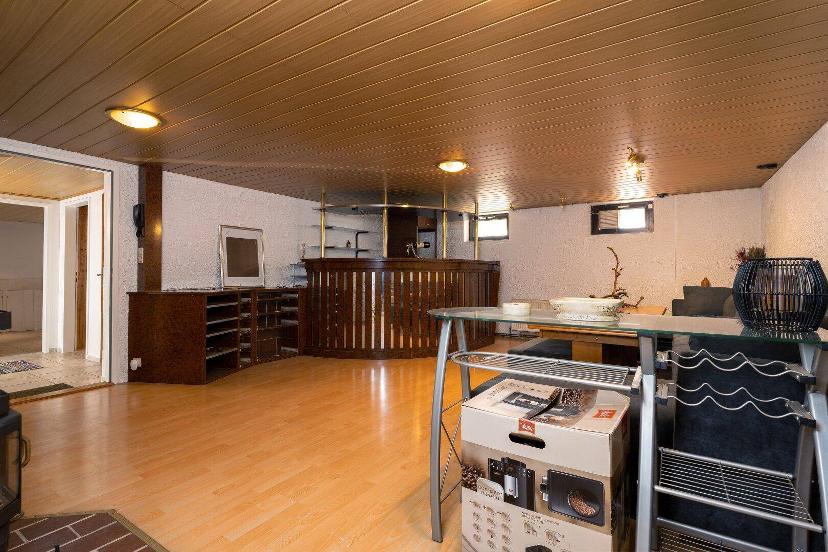 Ausgebauter Kellerraum mit Bar, Holzboden und gemütlicher Atmosphäre.