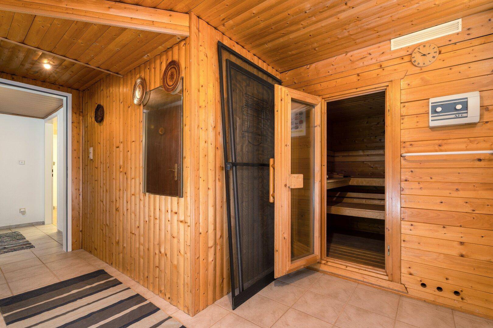 Gemütlicher Saunabereich im Untergeschoss mit Holzverkleidung und Fliesenboden.