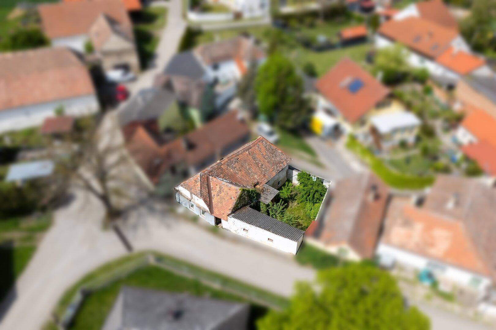 Vogelperspektive des Anwesens mit Ziegeldach und Garten, eingebettet in die ländliche Umgebung.