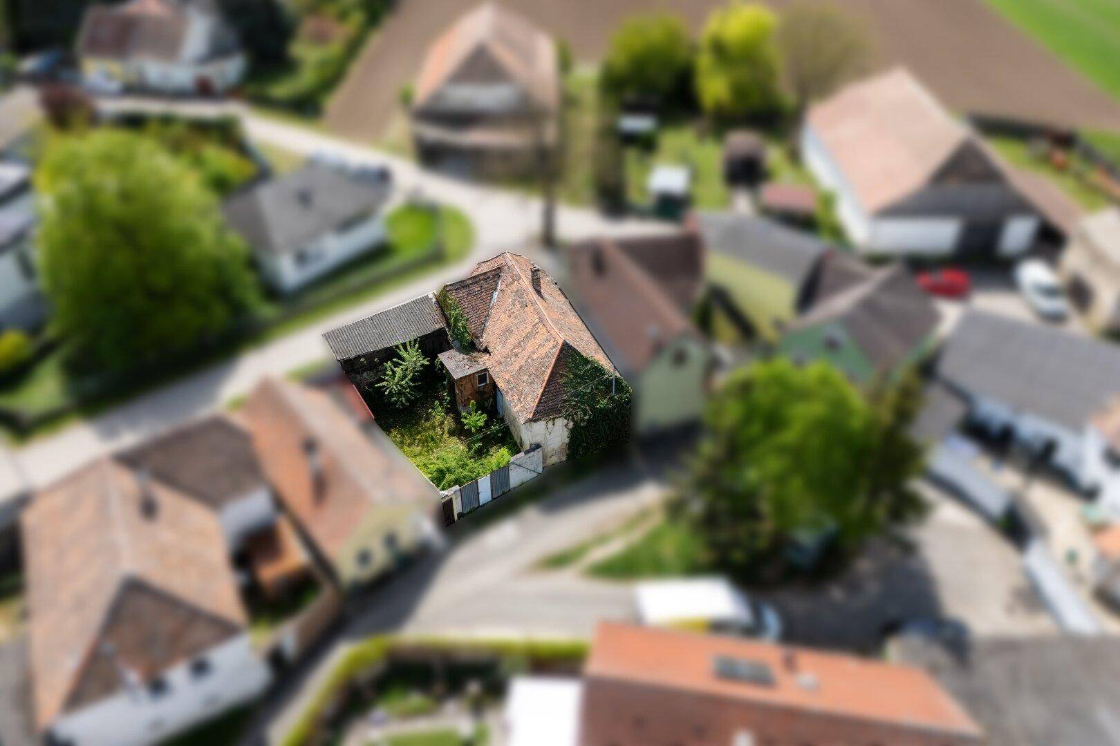 Luftaufnahme des Grundstücks mit dem Haus und dem Garten, umgeben von weiteren Gebäuden in ländlicher Lage.