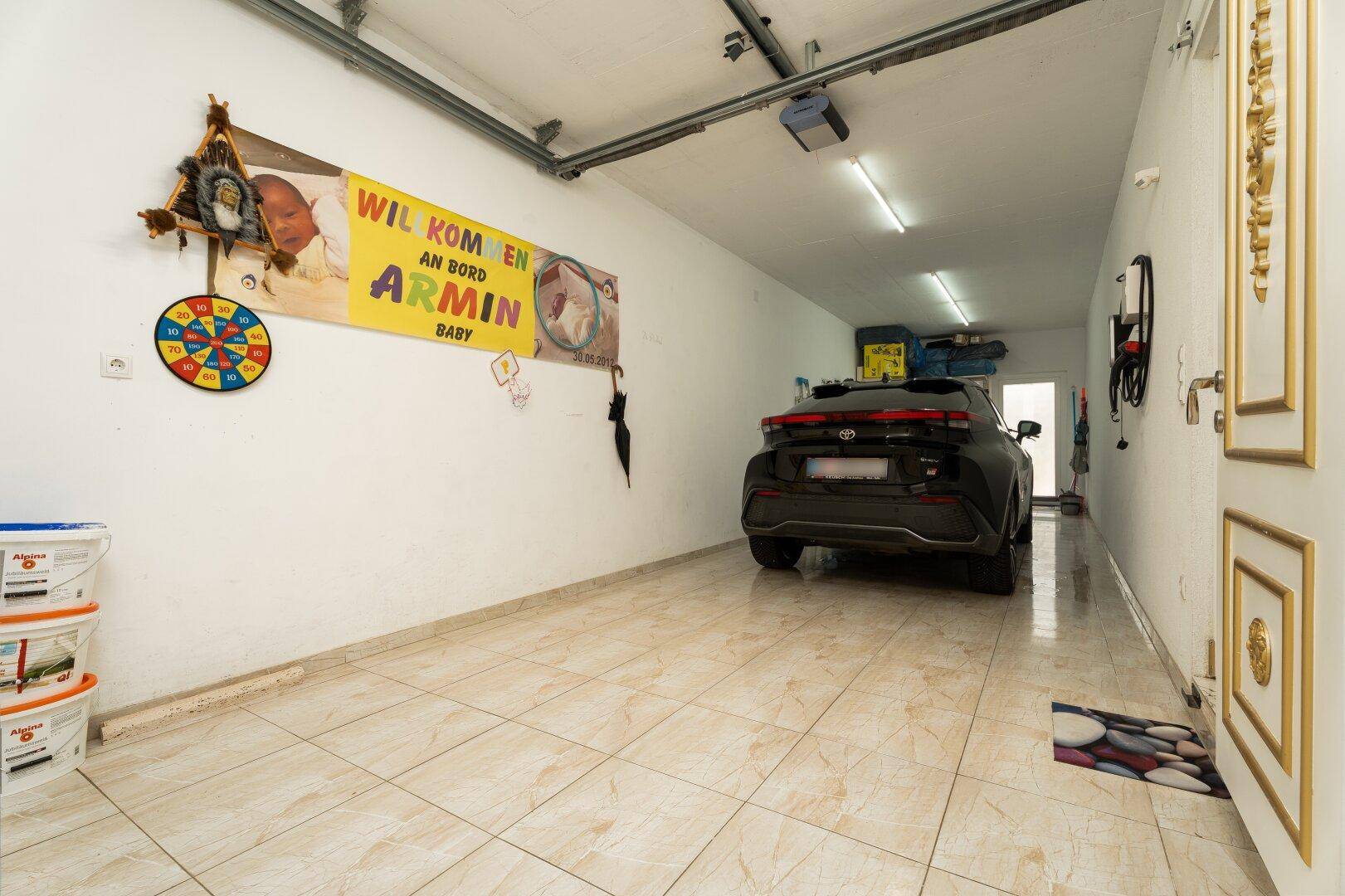 Geräumige Garage mit Fliesenboden und ausreichend Platz für ein Fahrzeug.