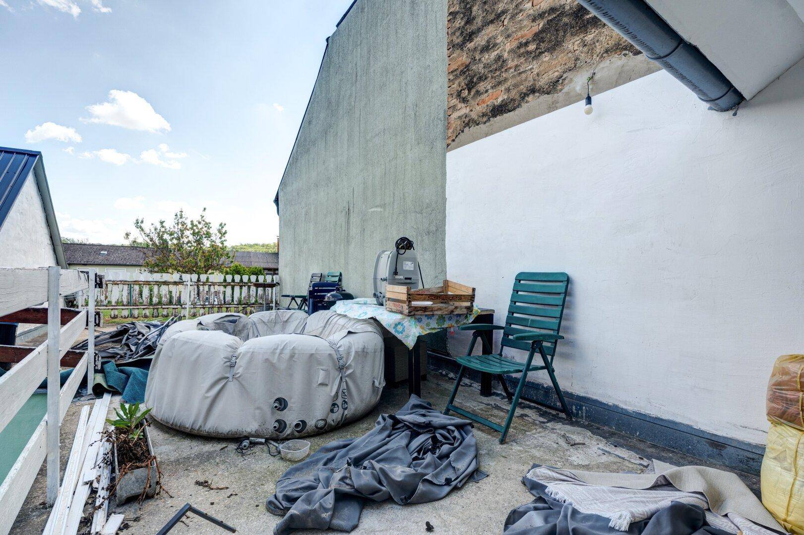 Dachterrasse mit aufblasbarem Whirlpool und einfacher Sitzgelegenheit.