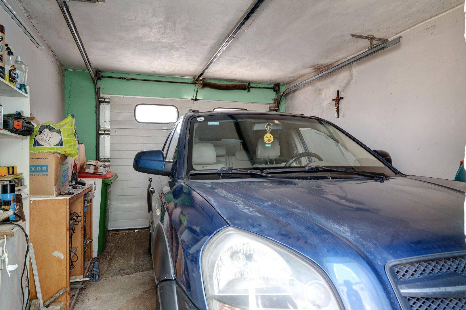 Garage mit einem geparkten Auto und Rolltor.