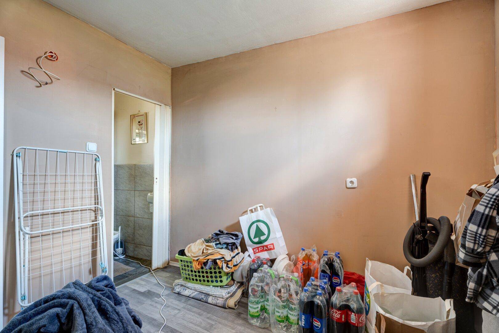 Hauswirtschaftsraum mit Wäscheständer und Abstellmöglichkeiten.
