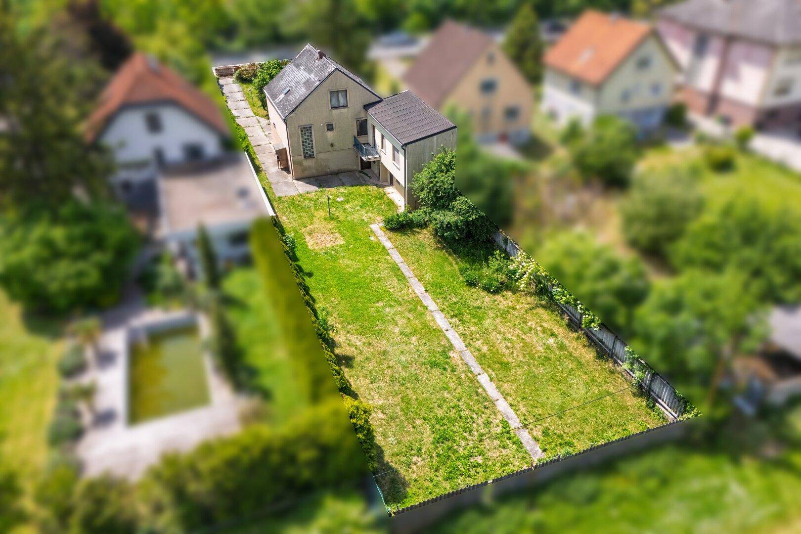 Luftaufnahme des Hauses mit langem, schmalem Garten und umliegenden Wohnhäusern.