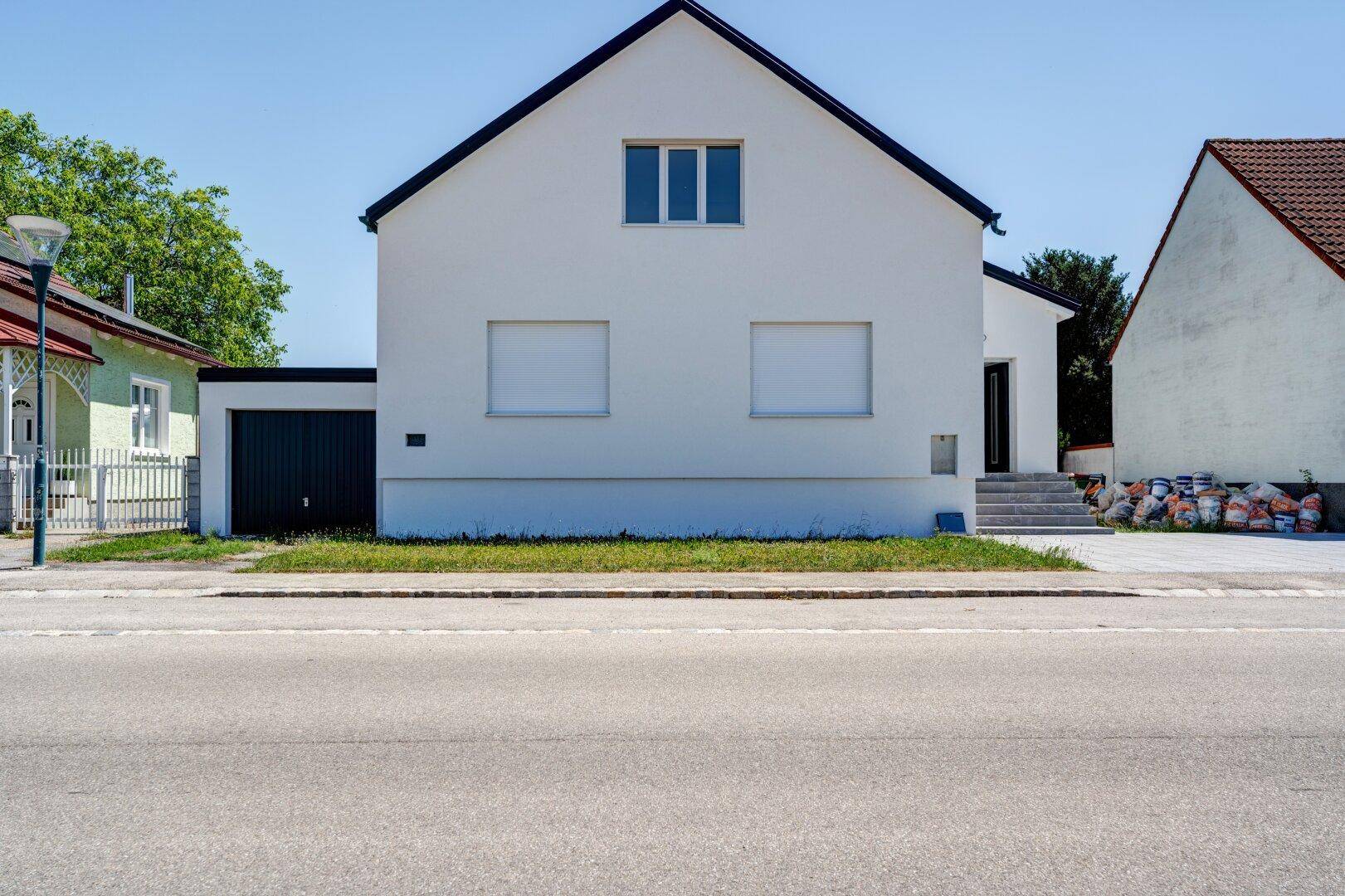 Vorderansicht des modernen Einfamilienhauses von der Straße aus gesehen.