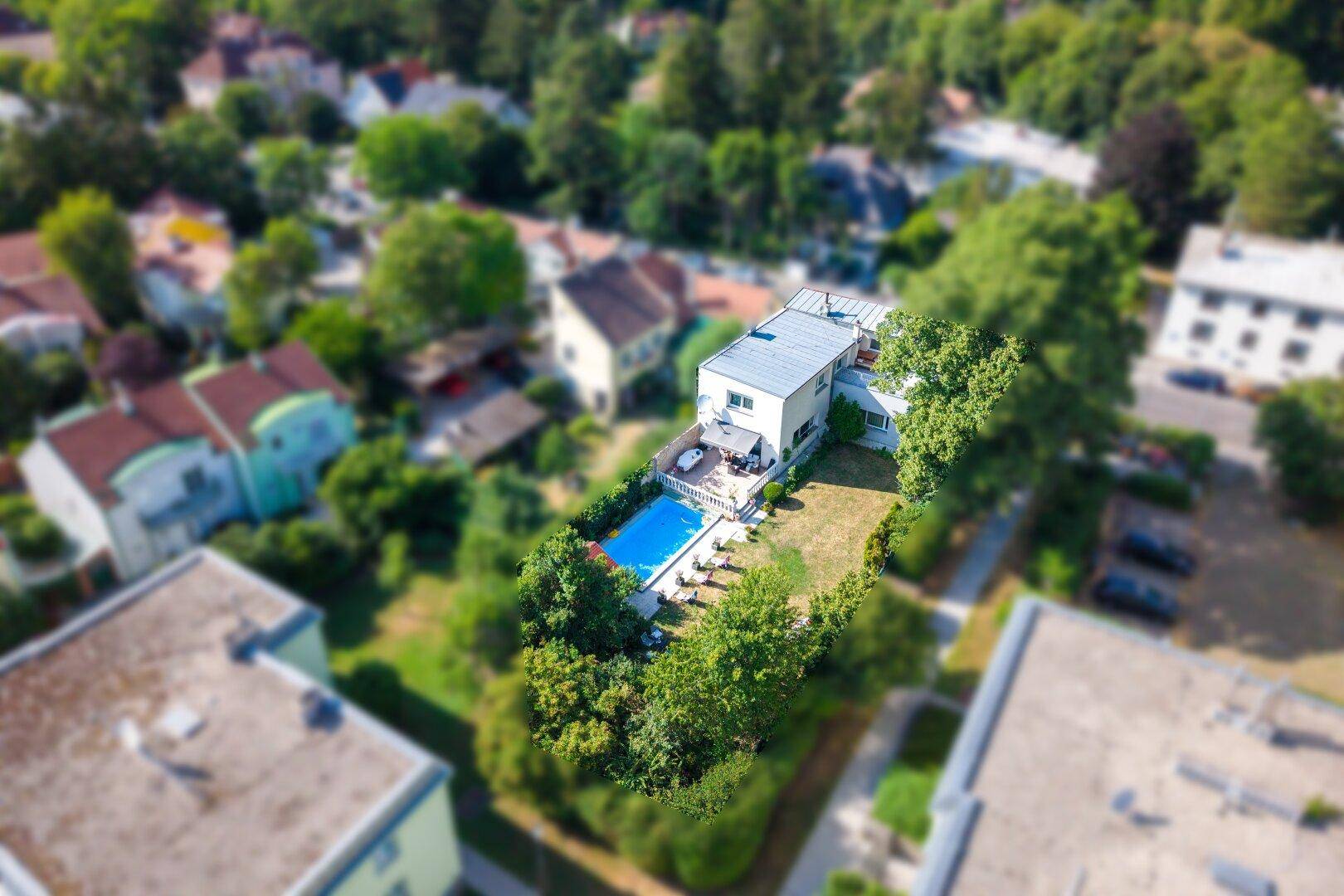 Luftaufnahme eines Hauses mit Swimmingpool und Garten in einer grünen Wohngegend.