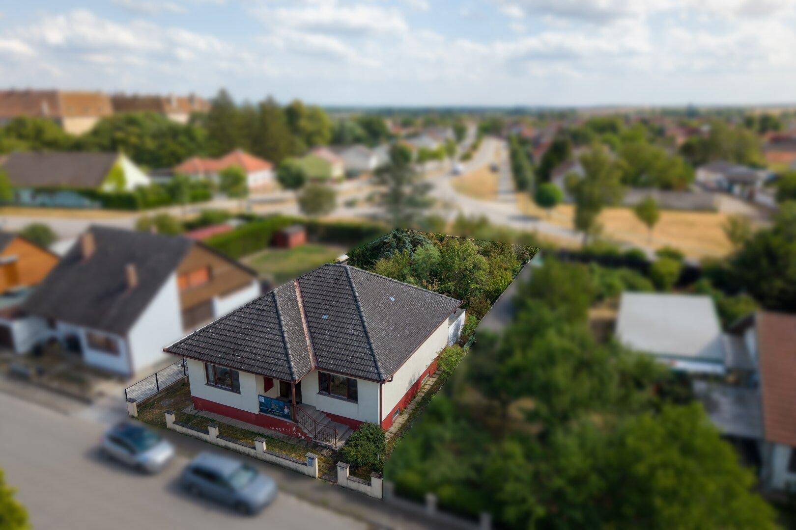 Weitläufige Luftaufnahme eines Hauses in einer Siedlung mit Blick auf die umgebende Landschaft.
