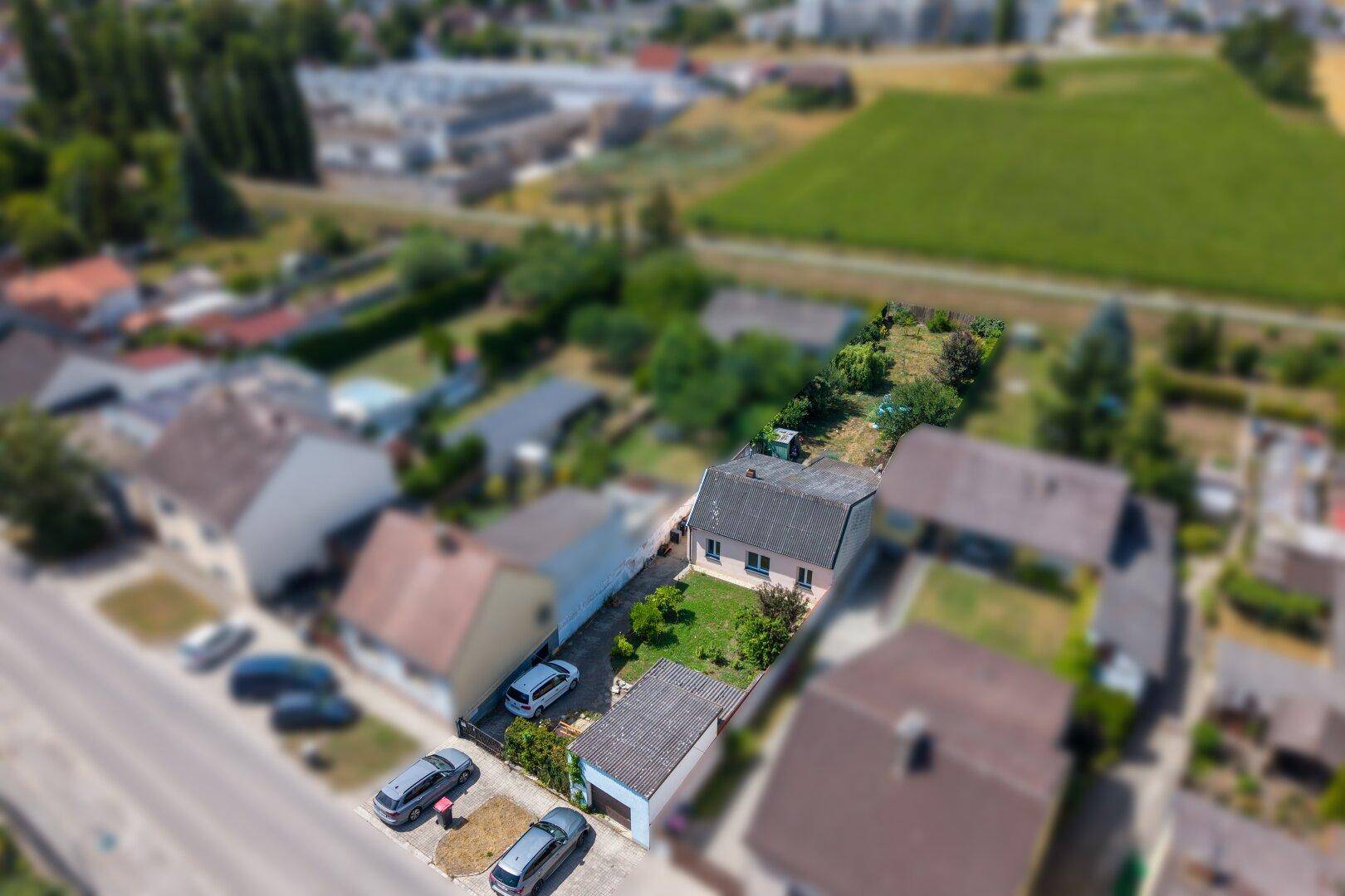 Luftaufnahme des Hauses mit Garten, Zufahrt und umliegender ländlicher Bebauung.