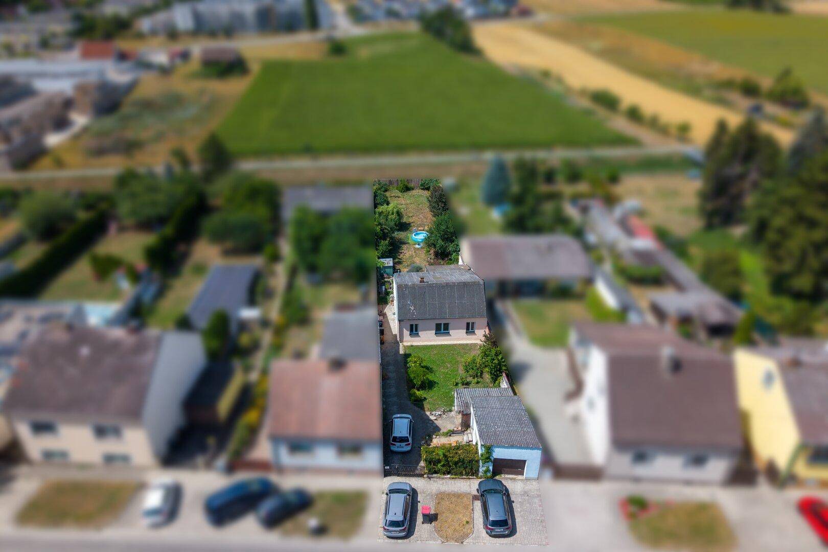 Übersicht aus der Vogelperspektive mit dem Grundstück, angrenzenden Häusern und weiten Feldern.
