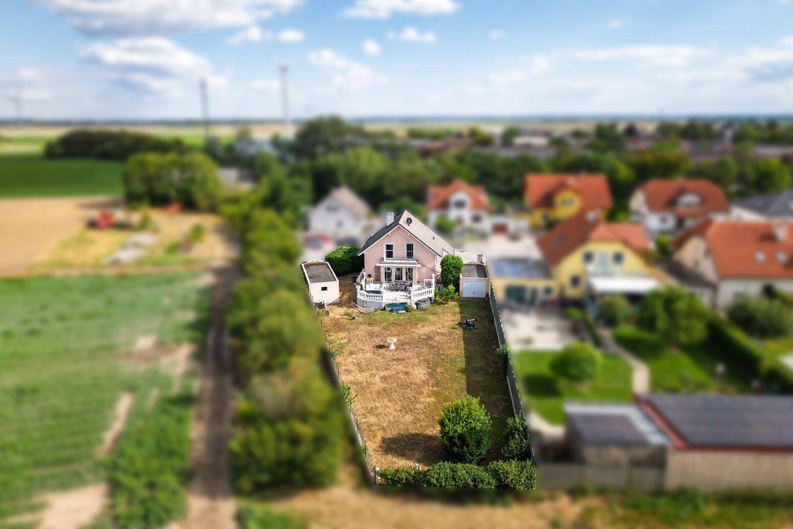 Luftaufnahme des Hauses mit großem Grundstück und umliegenden Feldern in ländlicher Umgebung.