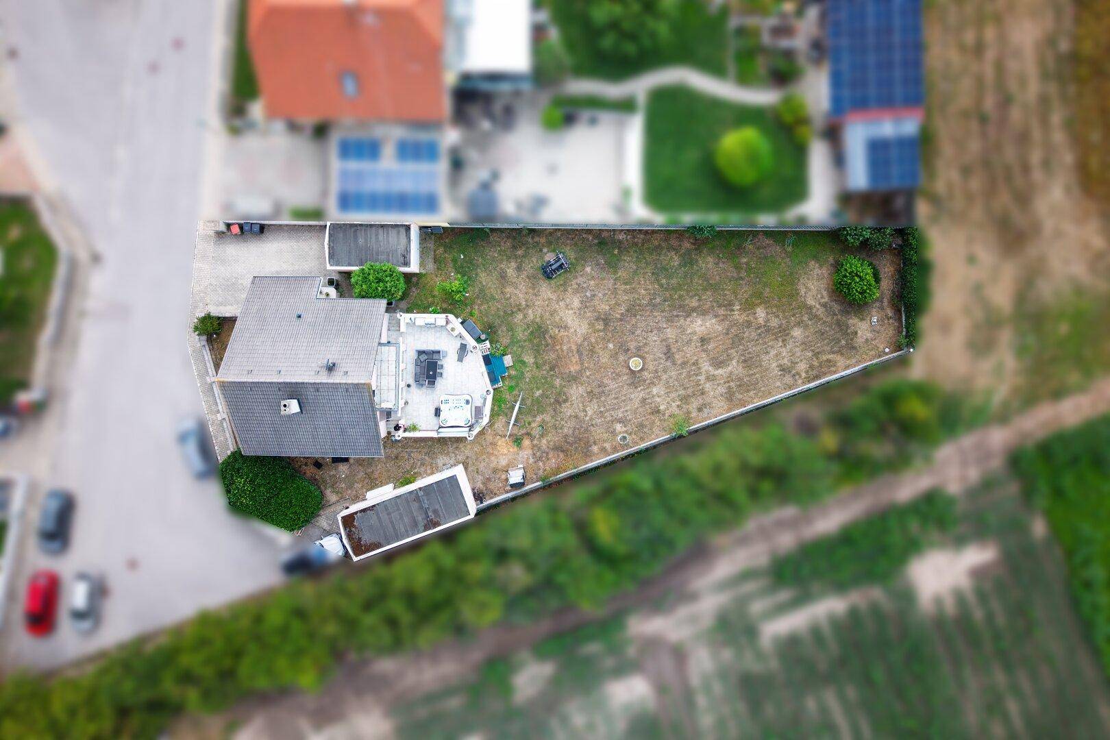 Luftaufnahme des Hauses mit großem Garten, Terrasse und umliegender Landschaft.