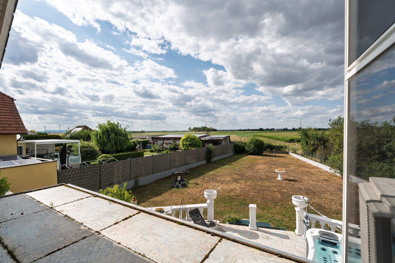 Geräumiger Balkon mit Panoramablick auf Felder und grüne Landschaft.