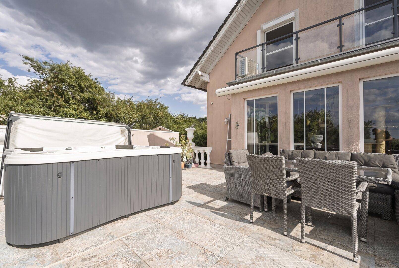 Großzügige Terrasse mit Whirlpool und bequemen Lounge-Möbeln, ideal zum Entspannen.