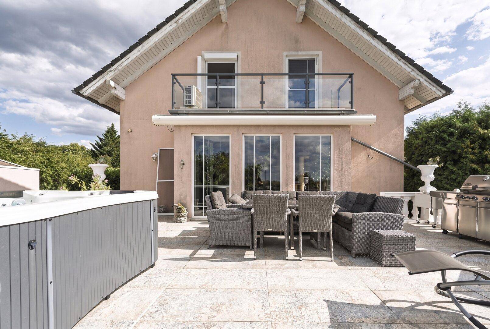 Große Terrasse mit Whirlpool, Grillbereich und bequemen Sitzgelegenheiten für gesellige Stunden.