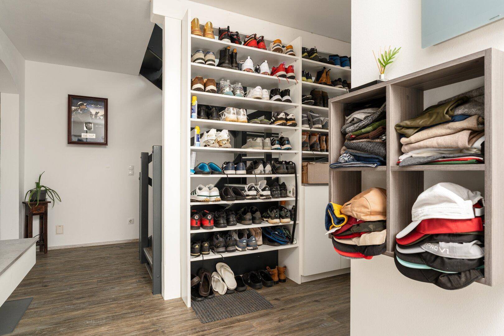 Heller Eingangsbereich mit praktischem Schuhregal und modernem Bodenbelag.