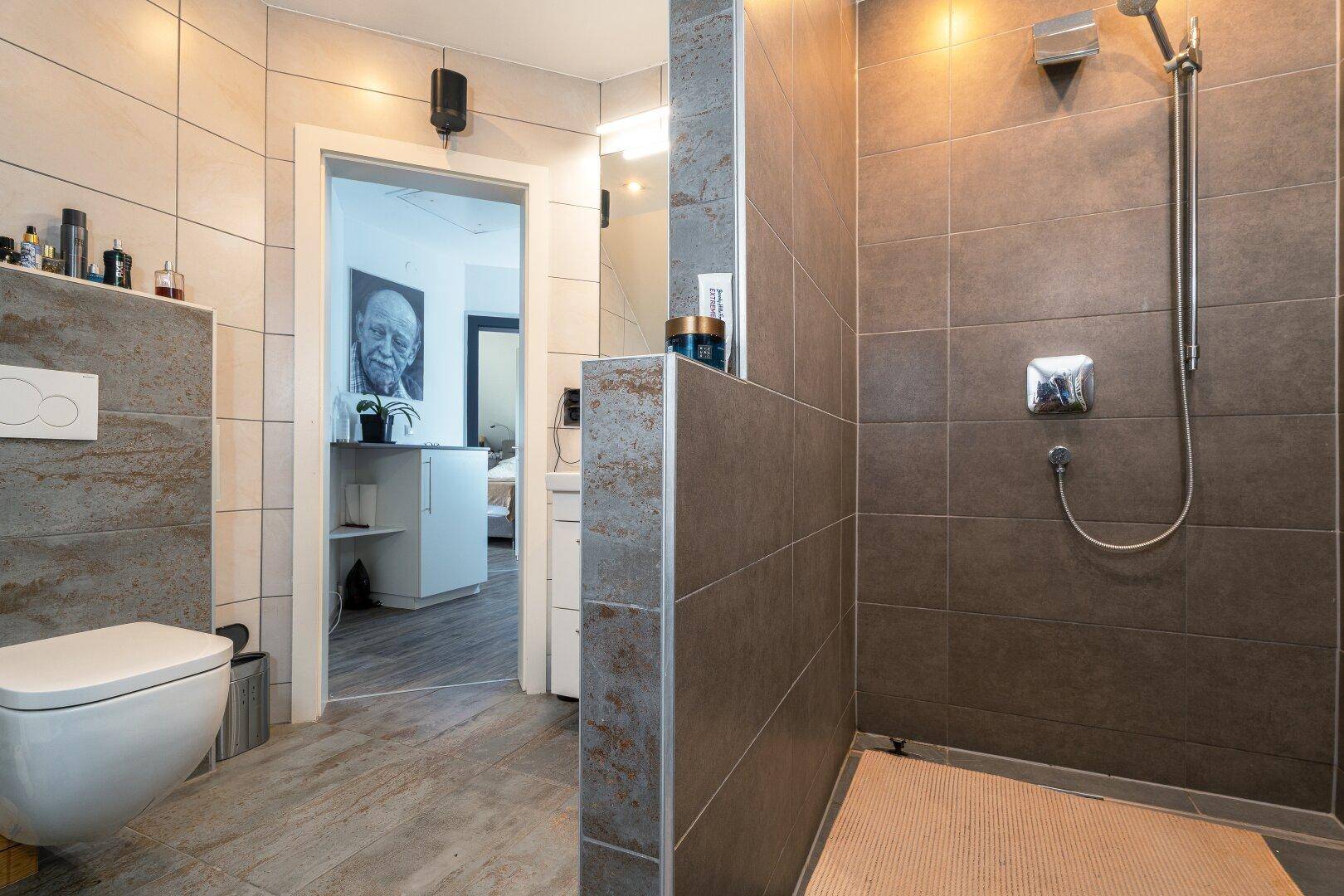 Modernes Badezimmer mit begehbarer Dusche, Wand-WC und stilvollen Fliesen.