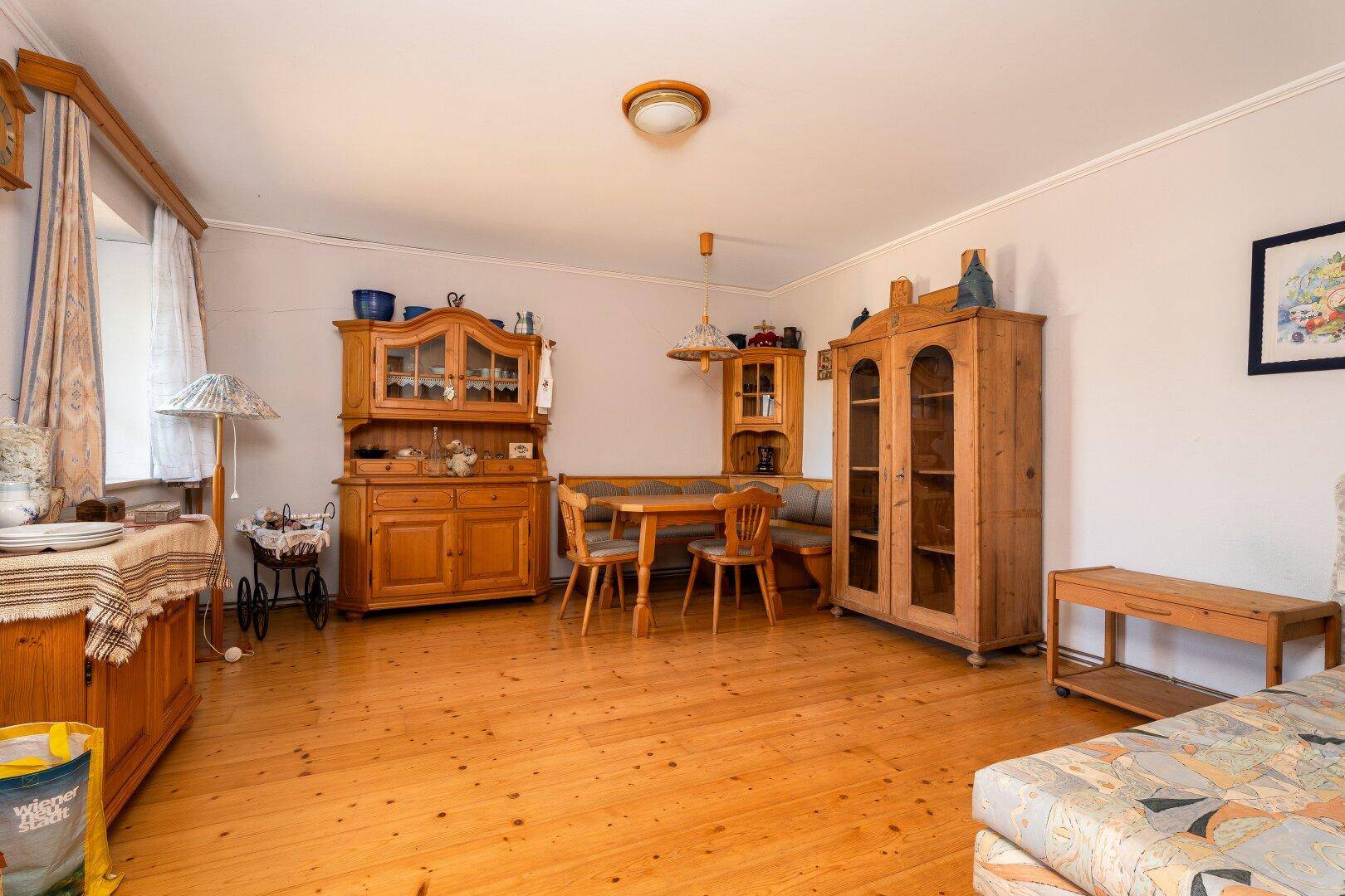 Gemütlicher Wohn- und Essbereich mit Holzboden und traditionellen Holzmöbeln.