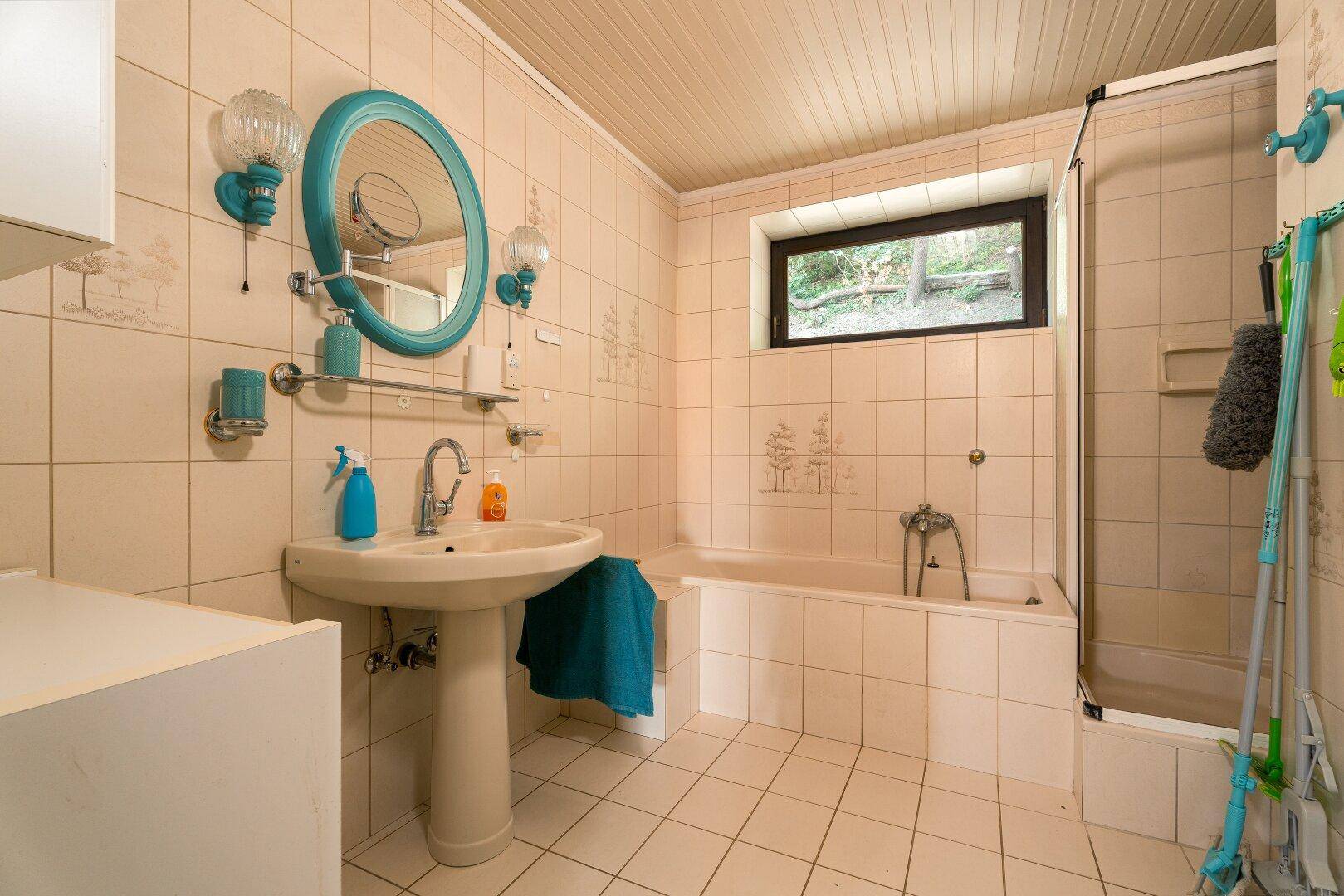 Badezimmer mit Badewanne, Dusche und Waschbecken, in einem traditionellen Stil gehalten.