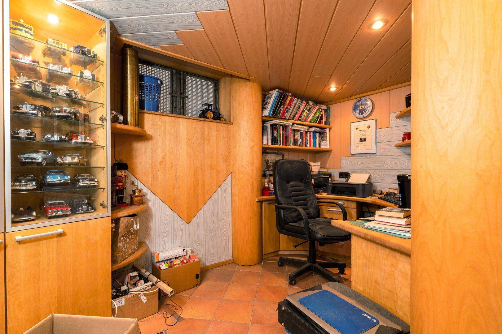 Büro im Keller mit Holzverkleidung, Schreibtisch und Bücherregal, ideal für Home-Office.