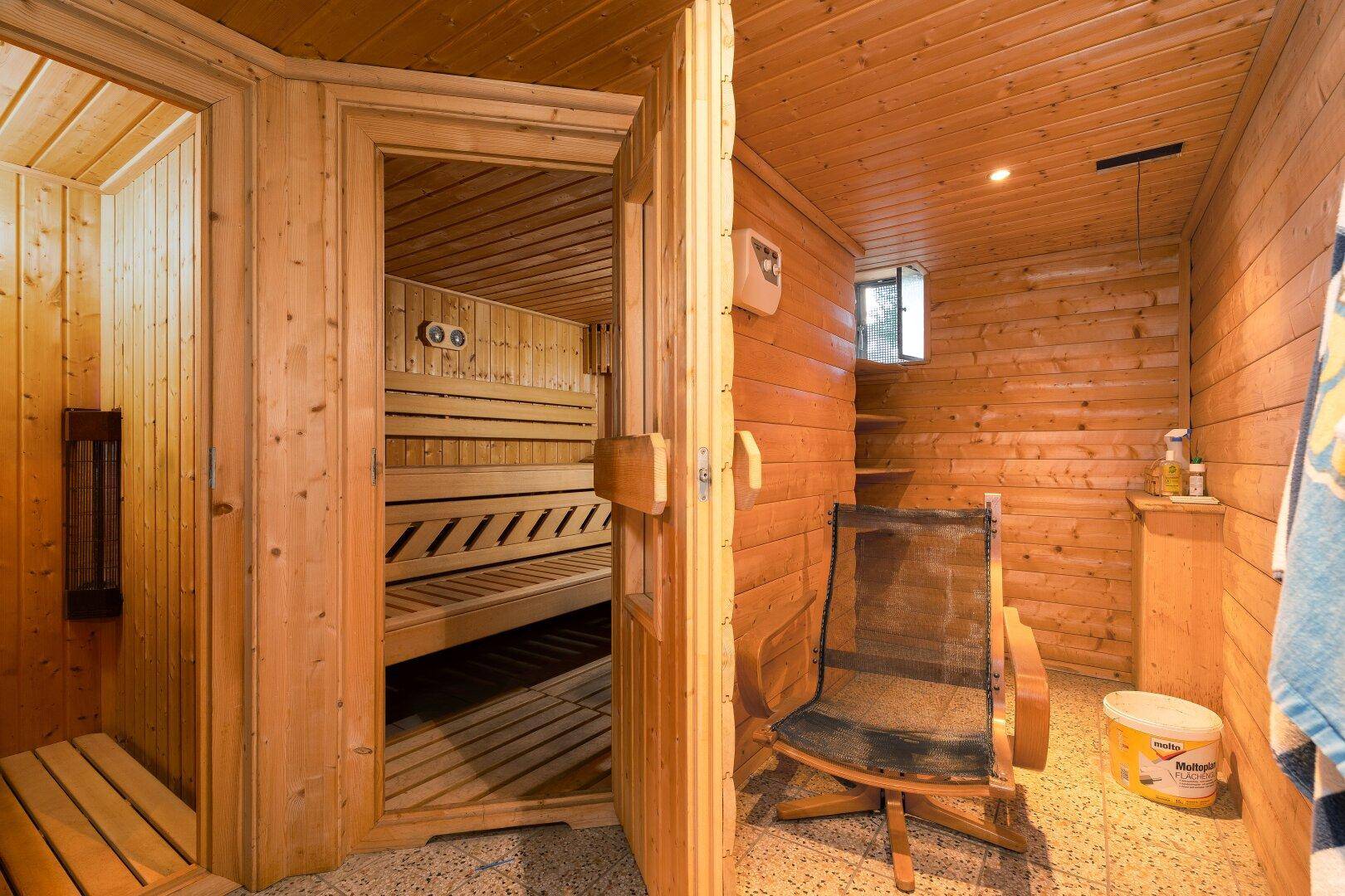 Traditionelle Holzsauna mit Bänken und einem Entspannungsbereich, ideal für Wellness.