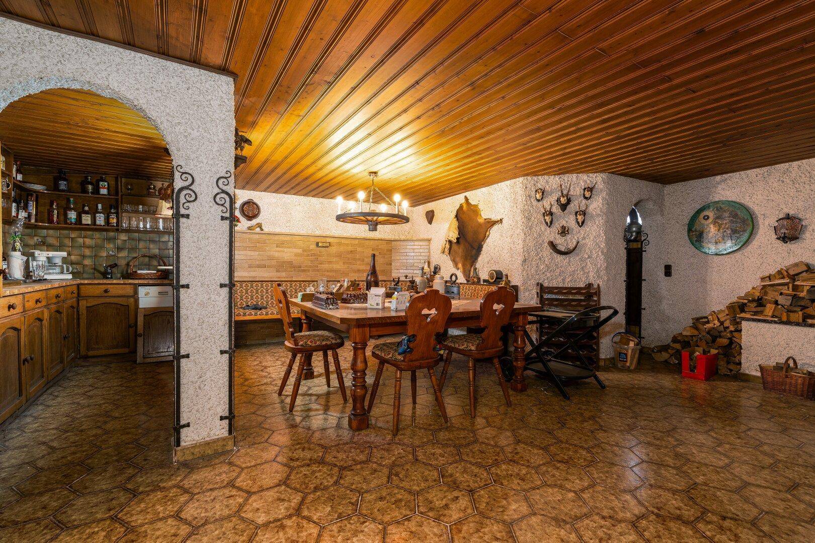 Rustikaler Essbereich mit Holztisch, Kachelofen und traditioneller Dekoration, sehr gemütlich.