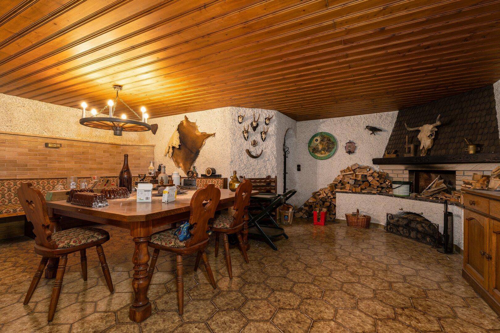 Gemütlicher Essbereich mit großem Holztisch, Kamin und rustikalen Fliesen, perfekt für Familienessen.