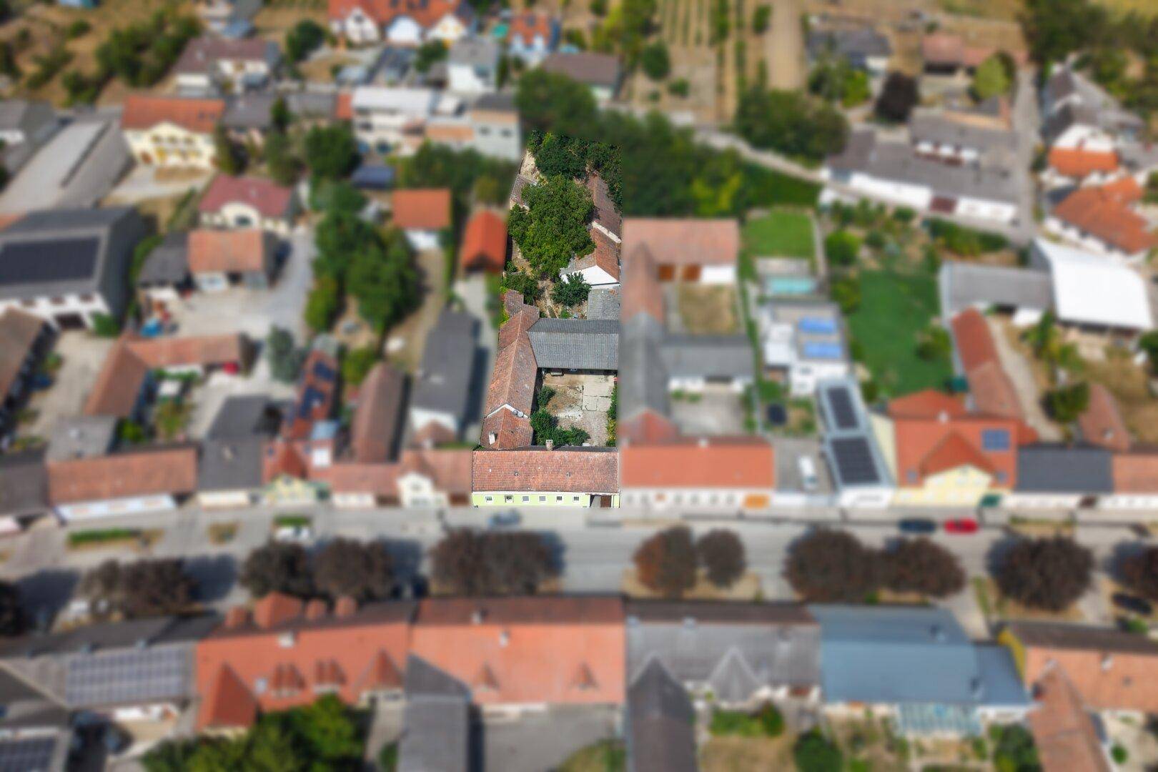 Schräge Luftaufnahme des Anwesens und der umliegenden ländlichen Nachbarschaft mit Feldern.