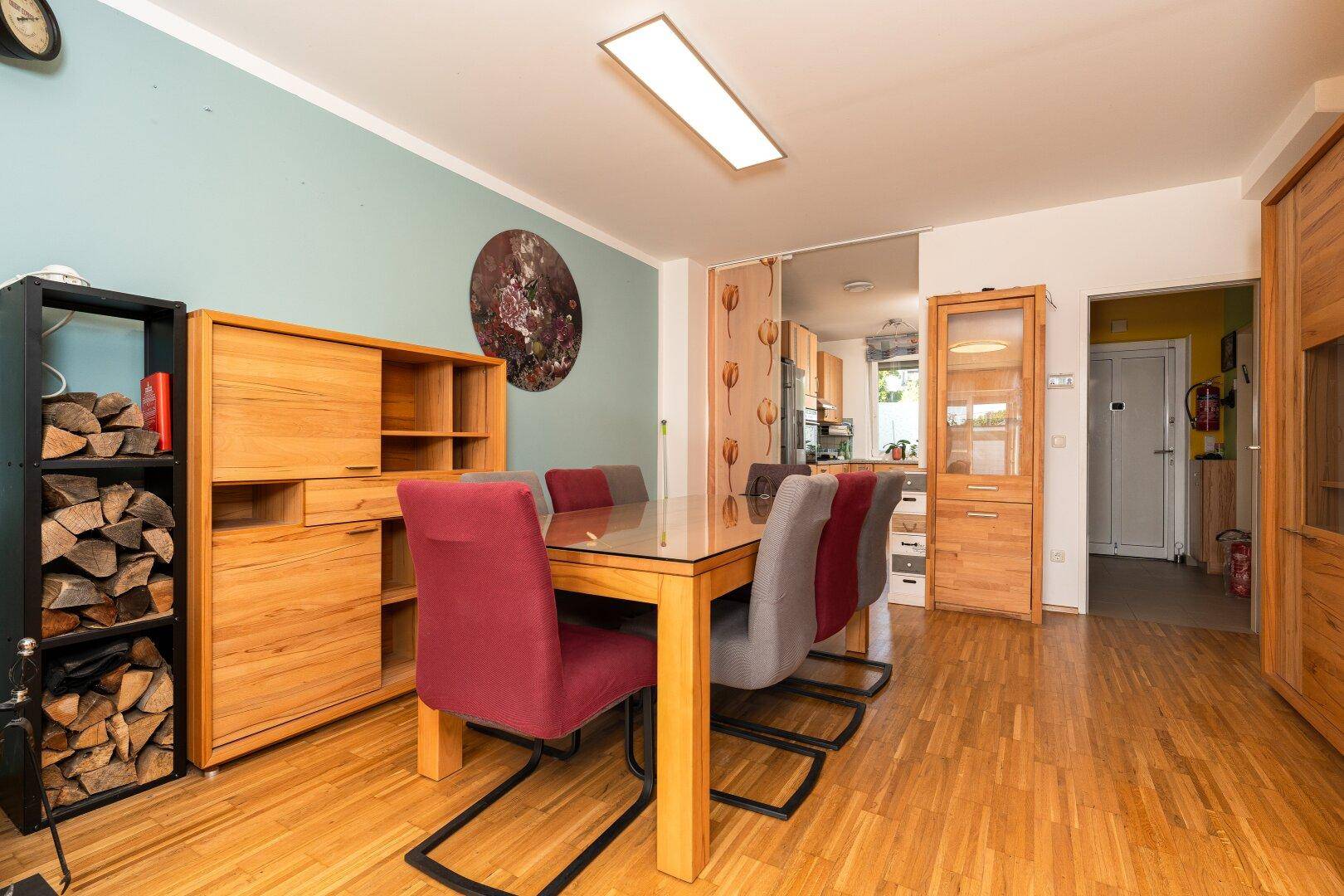 Essbereich mit Holztisch, Sideboard und Zugang zur Küche, ideal für gesellige Mahlzeiten.
